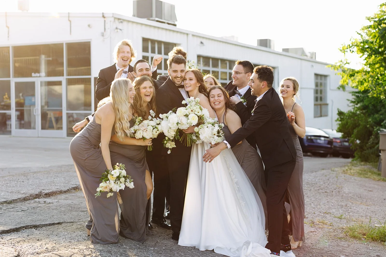 Bridal party florals of white garden roses, peonies, ranunculus, sweet peas, scabiosa, butterfly ranunculus and dark greenery in floral hues of white, cream, and blush. Designed by Rosemary and Finch in Nashville, TN.
