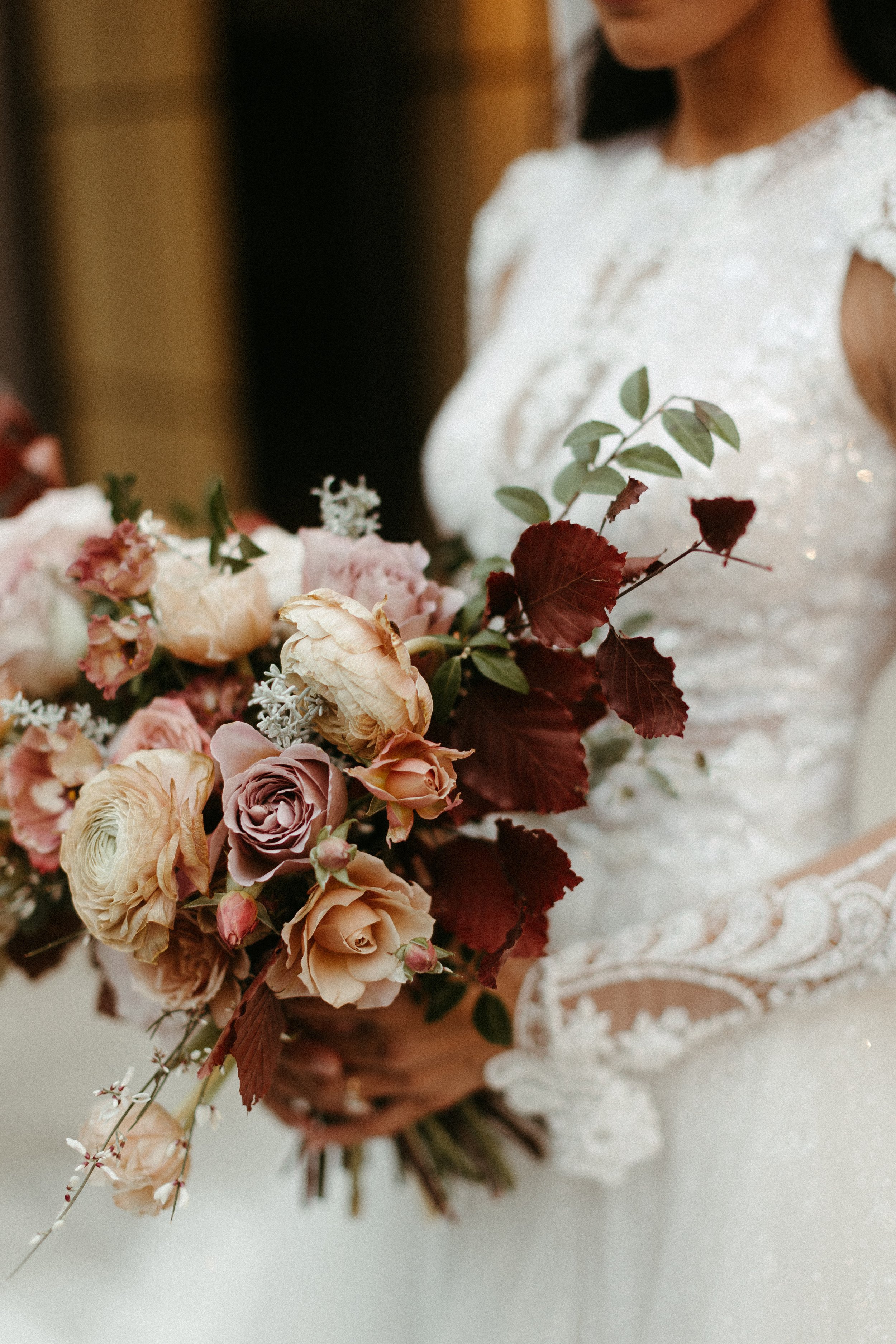 This elegant bridal bouquet brought hues of mauve, dusty pink, cream, burgundy, and terra cotta to this winter wedding. Lush with petal heavy roses, ranunculus, spray roses, copper beech, and greenery. Designed by Rosemary and Finch in Nashville, TN.