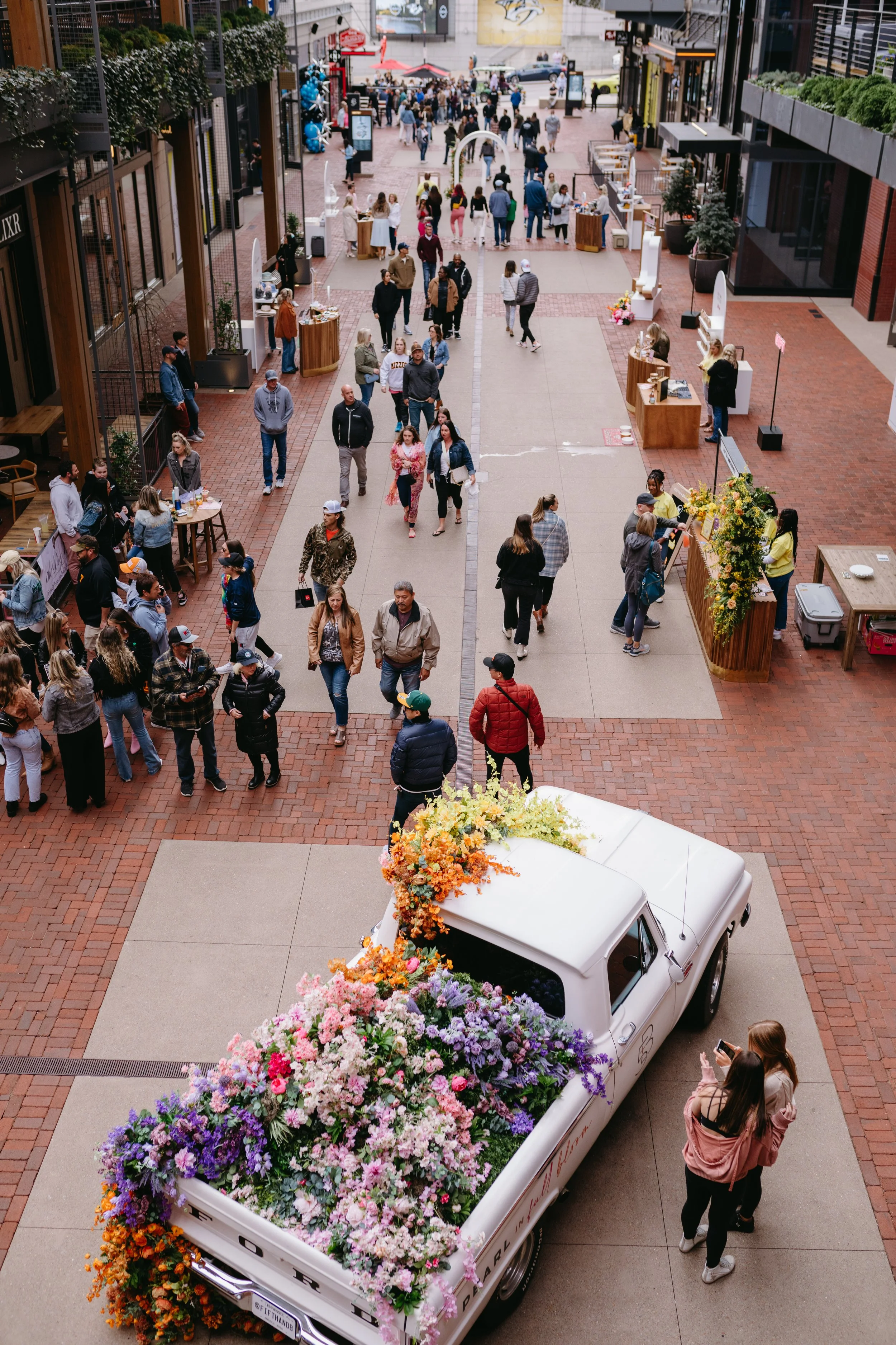 Cheerful pickup truck installation composed of silk floral hues in pink, magenta, lavender, coral, orange, yellow, and mixed greens bring to life this spring Fifth + Broadway event in Nashville, TN. Design by Rosemary and Finch.