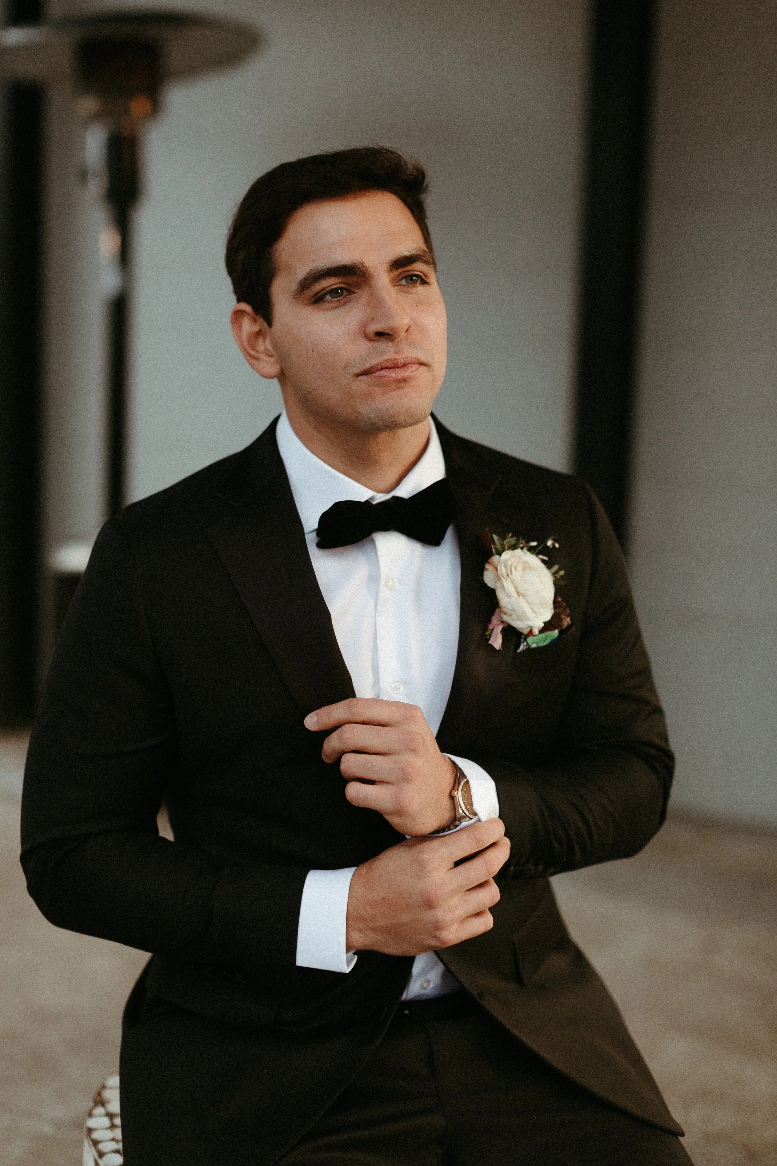 Boutonnieres of lush ranunculus and greenery decorate this 1920s inspired wedding bridal party. Neutral hues with accents of sage green and burgundy. Designed by Rosemary and Finch in Nashville, TN.