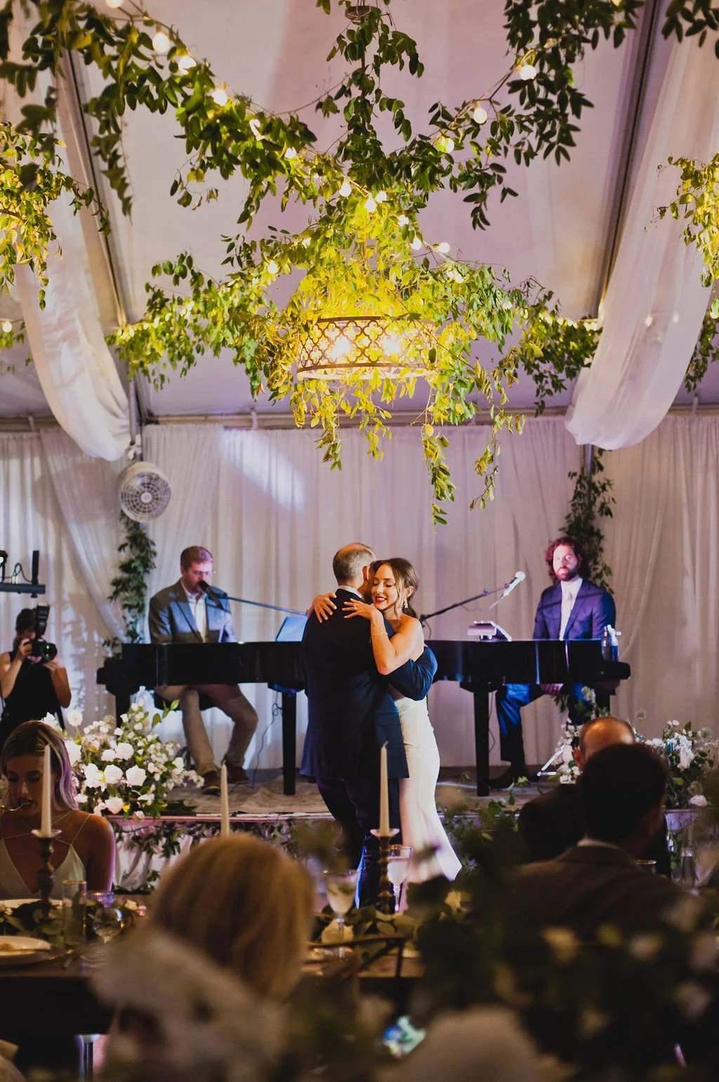 Gorgeous installations of smilax grew over the entrance to the tent, on the chandeliers, and all throughout the reception creating a warm, natural atmosphere. Designed by Rosemary and Finch in Nashville, TN.