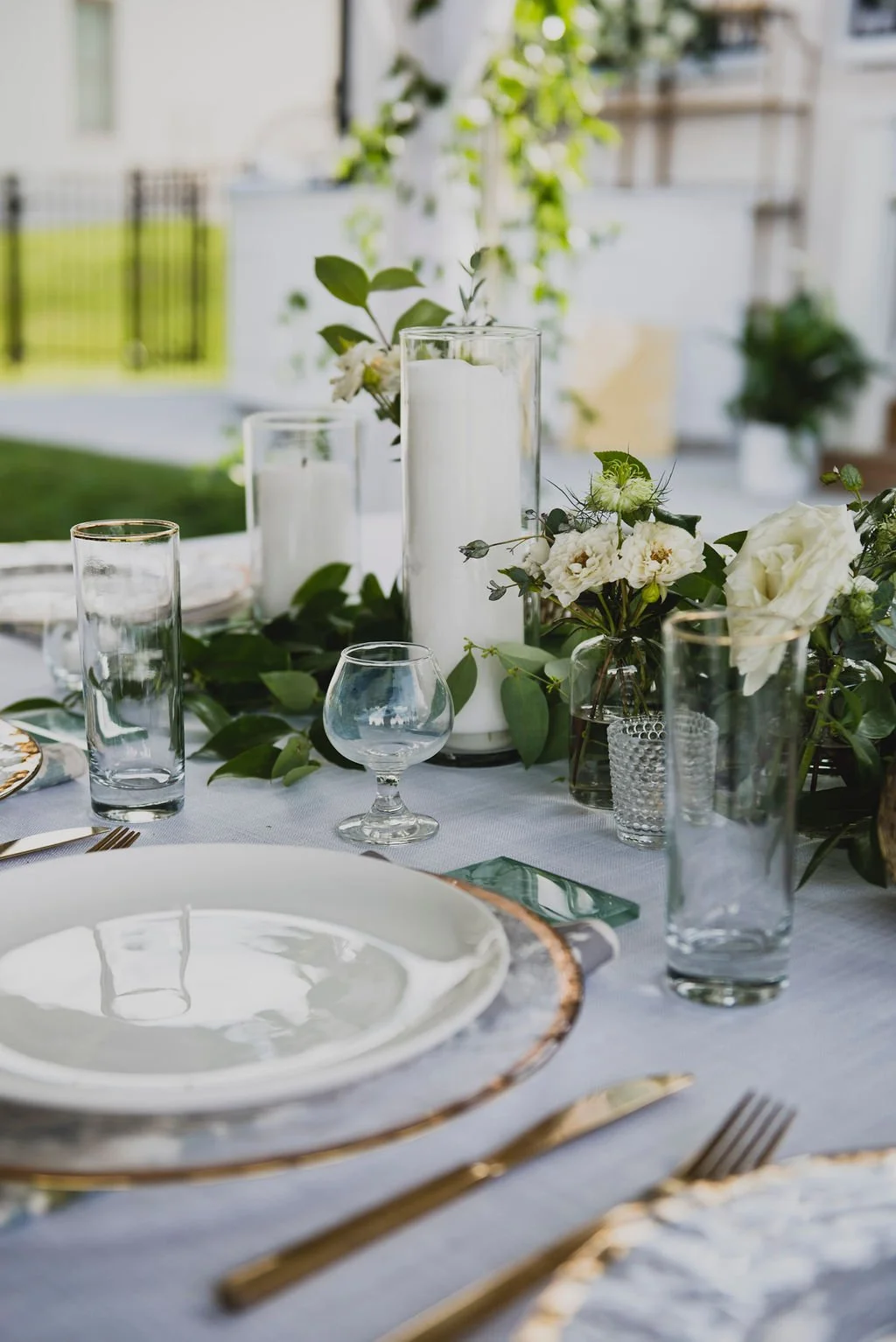 This backyard reception had a lush head table filled with garlands of eucalyptus, garden roses, ruscus, and spray roses. Designed by Rosemary and Finch in Nashville, TN.