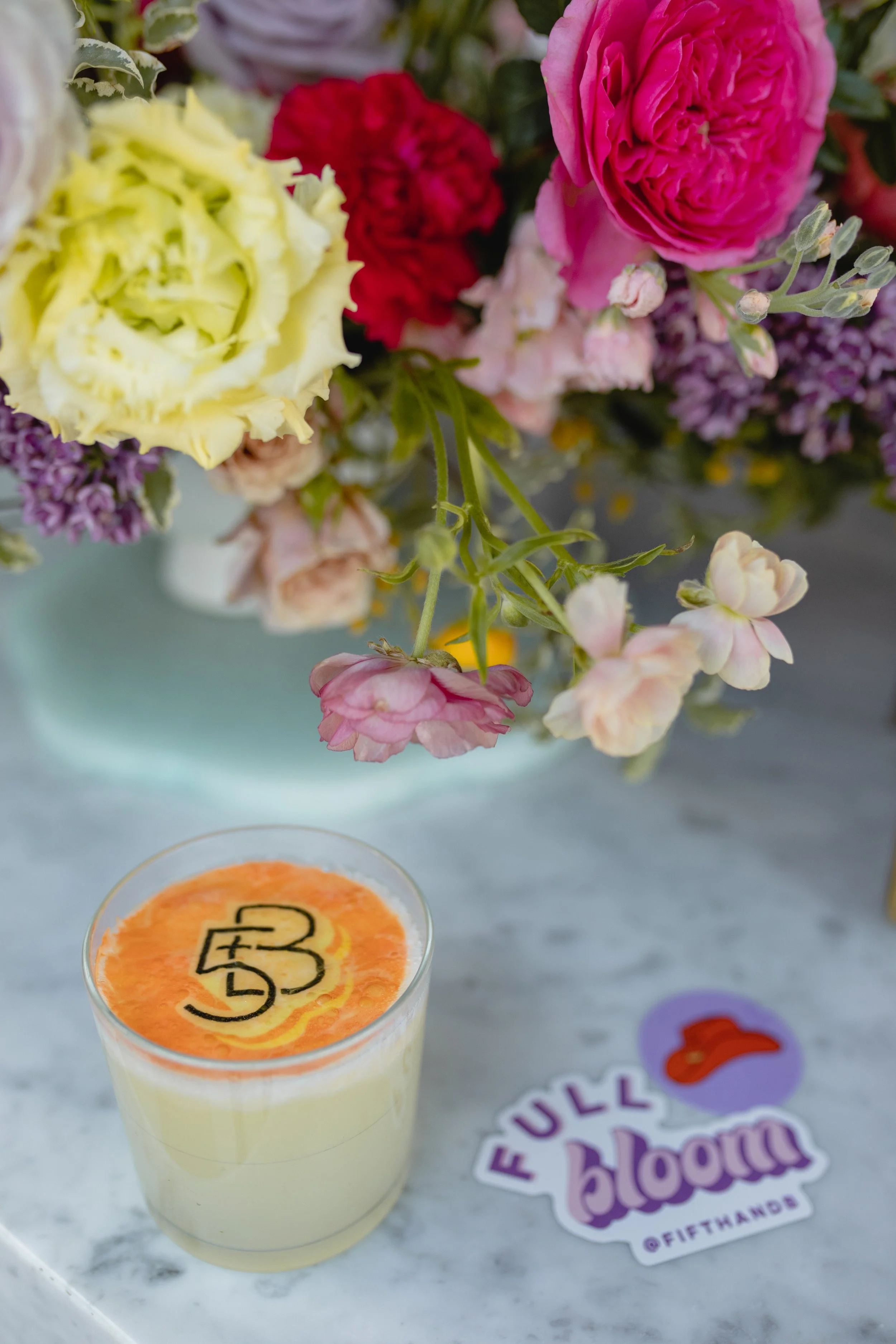 Bright spring floral hues of pink, lavender, coral, magenta, and yellow inspire the event space of Fifth + Broadway in Nashville, TN. Florals composed of roses, ranunculus, sweet peas, butterfly ranunculus, mixed greenery. Design by Rosemary and Finc
