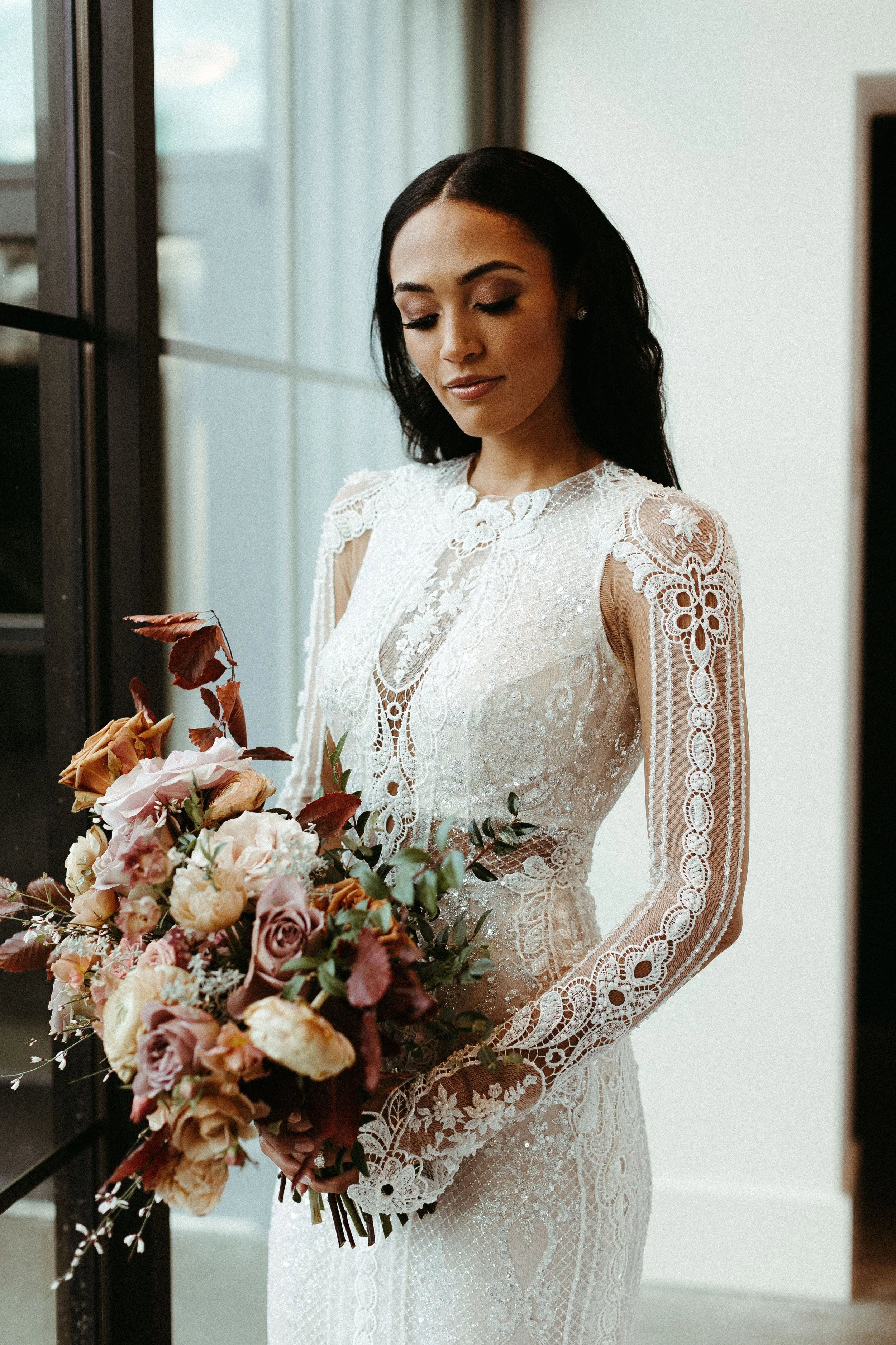 This elegant bridal bouquet brought hues of mauve, dusty pink, cream, burgundy, and terra cotta to this winter wedding. Lush with petal heavy roses, ranunculus, spray roses, copper beech, and greenery. Designed by Rosemary and Finch in Nashville, TN.