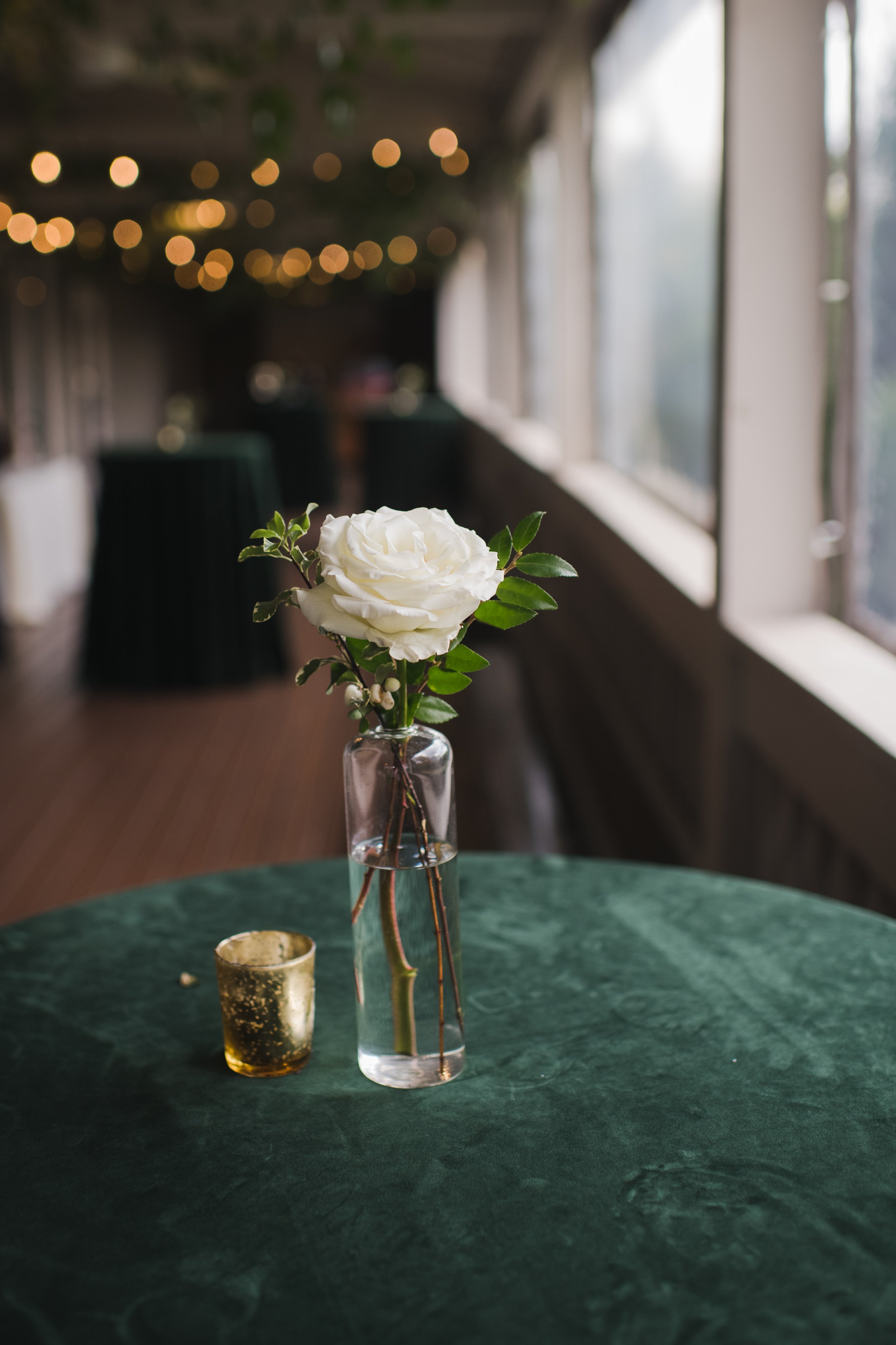 Classic garden-inspired white and greenery wedding flowers. Florals composed of roses, ranunculus, berries, and greenery. Designed by Rosemary and Finch in Nashville, TN.