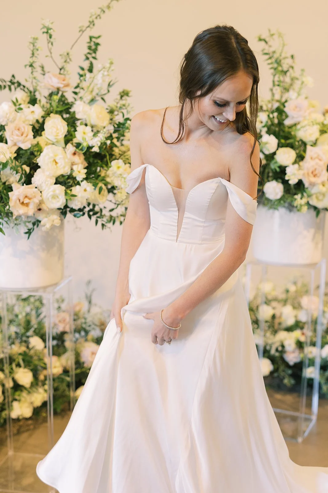 Lush ceremony installation featuring garden urns and meadows with petal heavy roses butterfly ranunculus, delphinium, and Queen Anne’s lace with natural, untamed greenery. Floral hues of white, cream, and blush. Designed by Rosemary and Finch in Nash