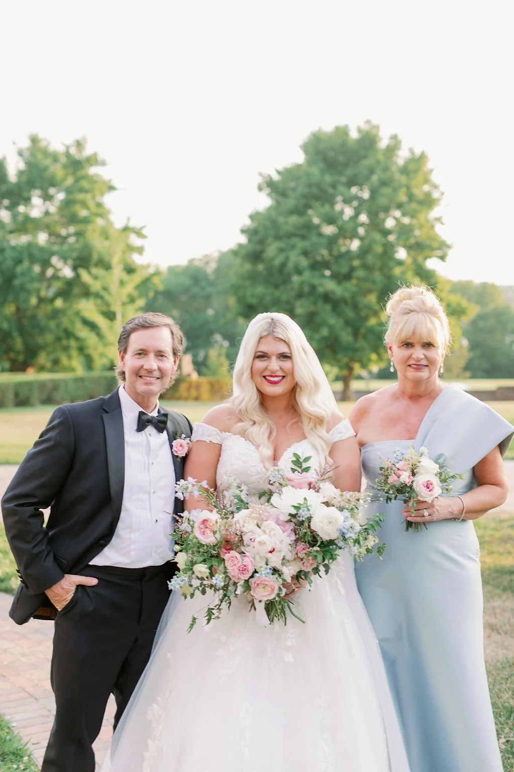 A lush bridal bouquet filled with hues of blush, pink, ivory, and hints of French blue. Garden roses, majolica spray roses, champagne roses, peonies, ranunculus, delphinium, and spirea make up this fairytale bouquet. Designed by Rosemary & Finch in N