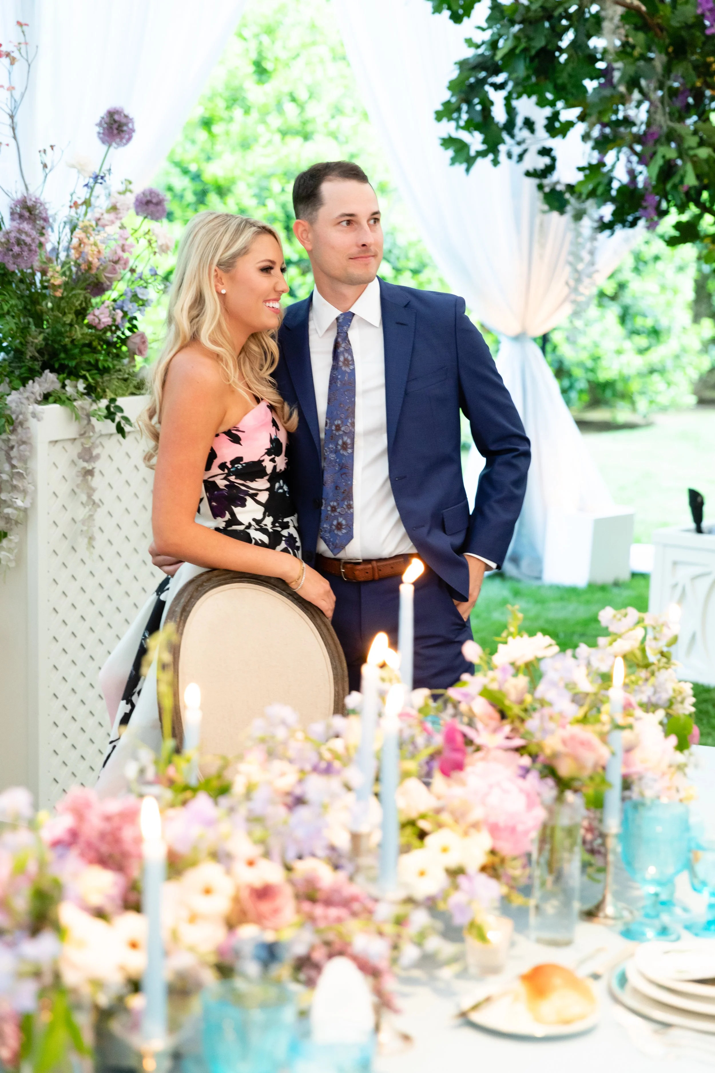 Growing, fresh floral centerpieces with blush garden roses, lilac, blue sweet peas, ranunculus, lavender delphinium, globe allium, and natural greenery for a tented Bridgerton inspired engagement party at a private home in Nashville, TN. Flower by Te