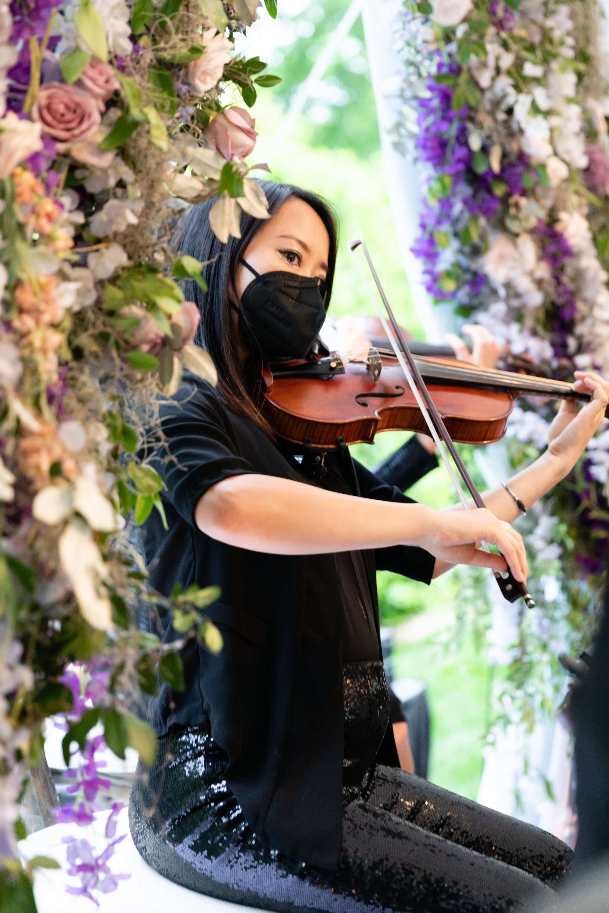 Growing, fresh floral installations with blush garden roses, lavender delphinium, wisteria, globe allium, and vines and greenery for a tented Bridgerton inspired engagement party at a private home in Nashville, TN. Flower by Tennessee based wedding f
