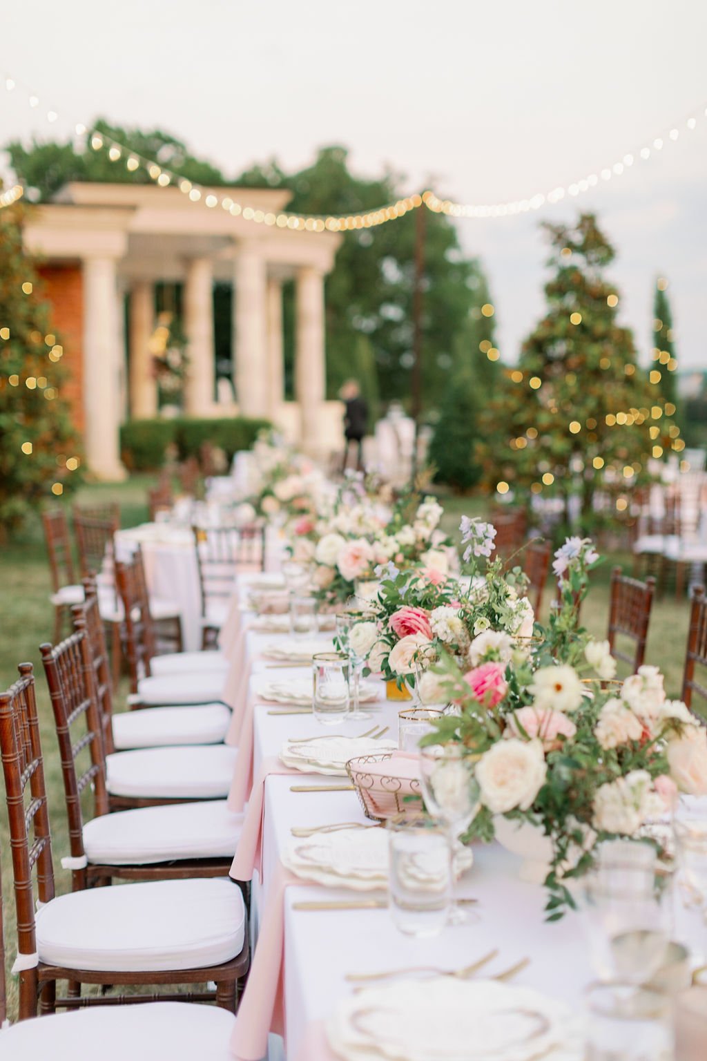 This garden-inspired reception features floral hues of blush, ivory, cream, pink, and hints of French blue along with centerpieces of pink roses, peonies, garden roses, blue delphinium, ranunculus, spirea and hydrangea. Designed by Rosemary & Finch i