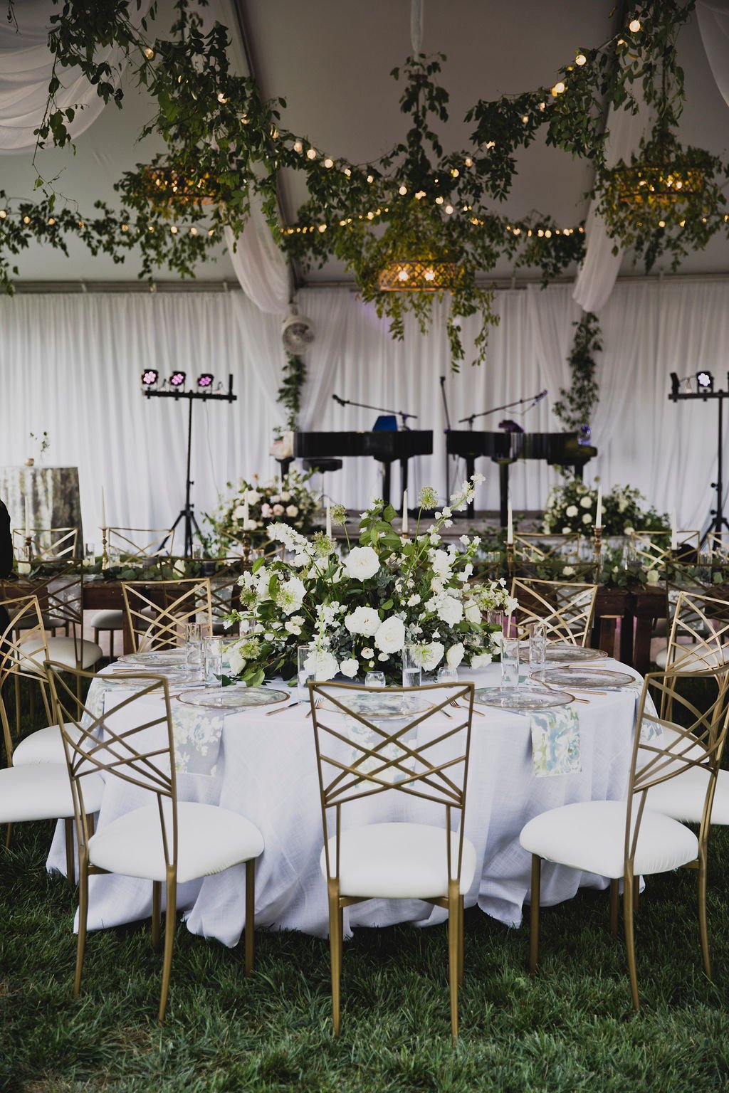 The centerpieces at this romantic summer wedding are filled with white ranunculus, garden roses, spray roses, delphinium, queen anne's lace, and lush greenery. Designed by Rosemary and Finch in Nashville, TN.