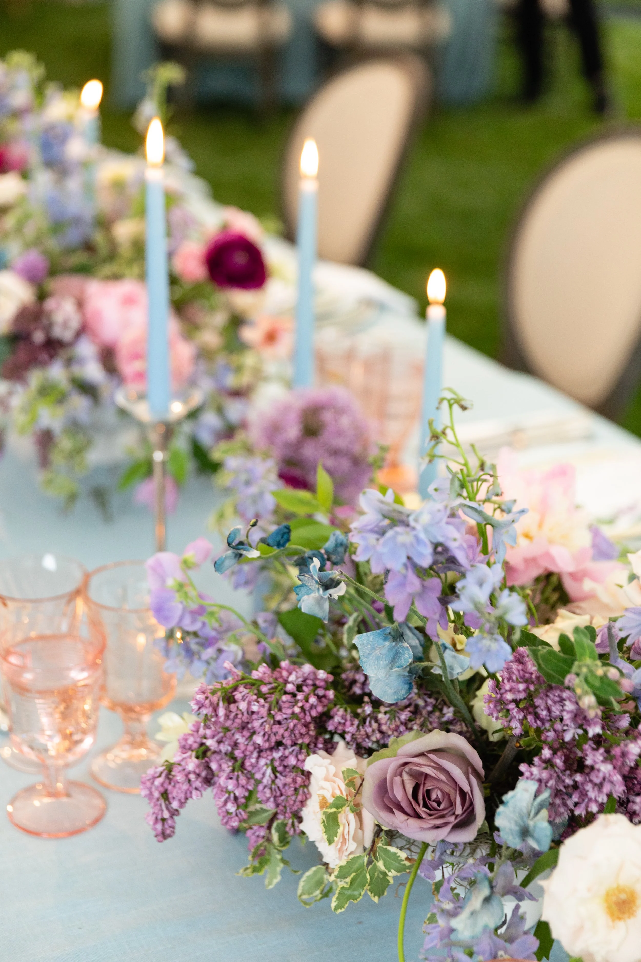 Growing, fresh floral centerpieces with blush garden roses, lilac, blue sweet peas, ranunculus, lavender delphinium, globe allium, and natural greenery for a tented Bridgerton inspired engagement party at a private home in Nashville, TN. Flower by Te