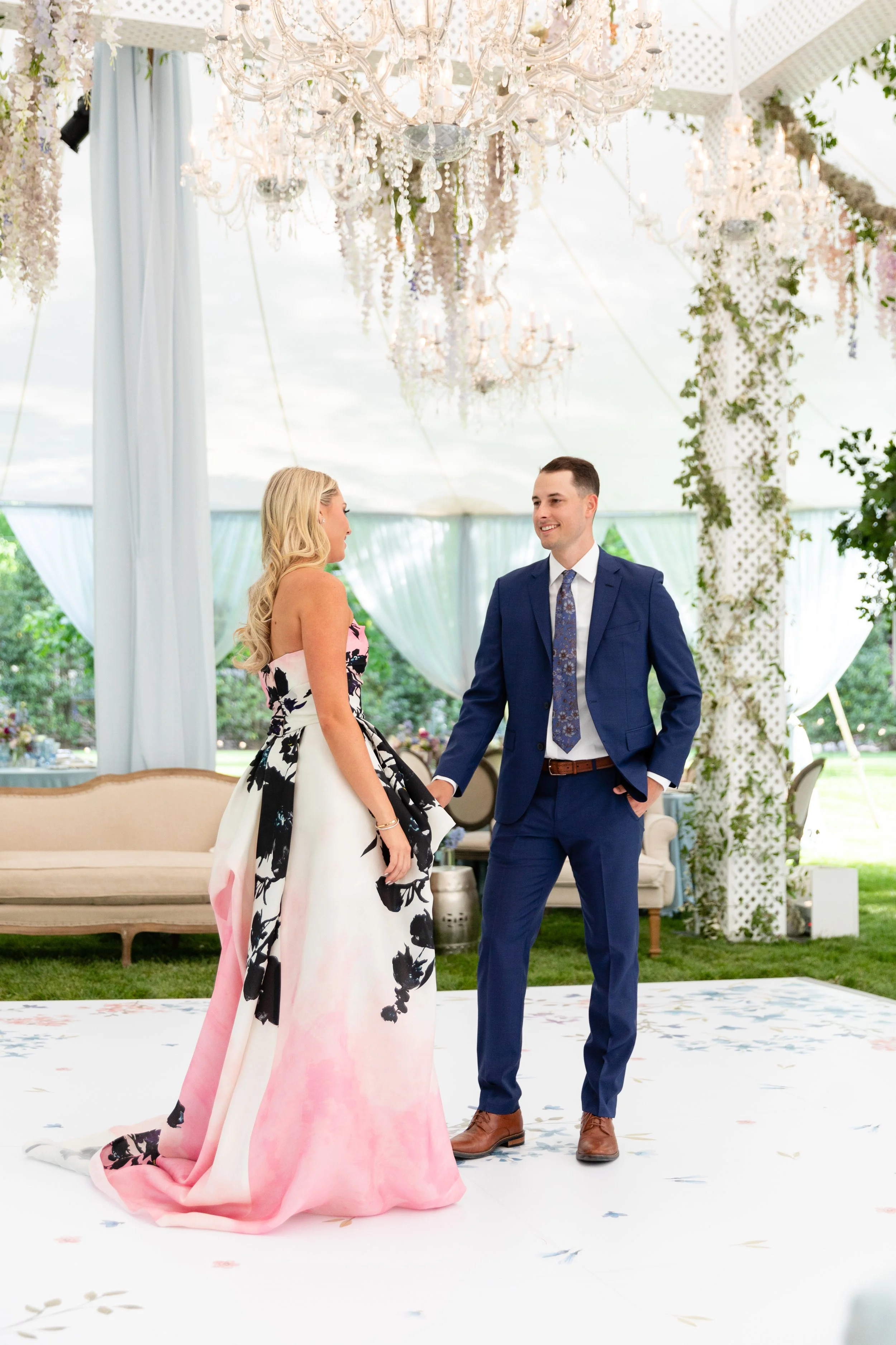 Growing, fresh floral installations with blush garden roses, lavender delphinium, wisteria, globe allium, and vines and greenery for a tented Bridgerton inspired engagement party at a private home in Nashville, TN. Flower by Tennessee based wedding f