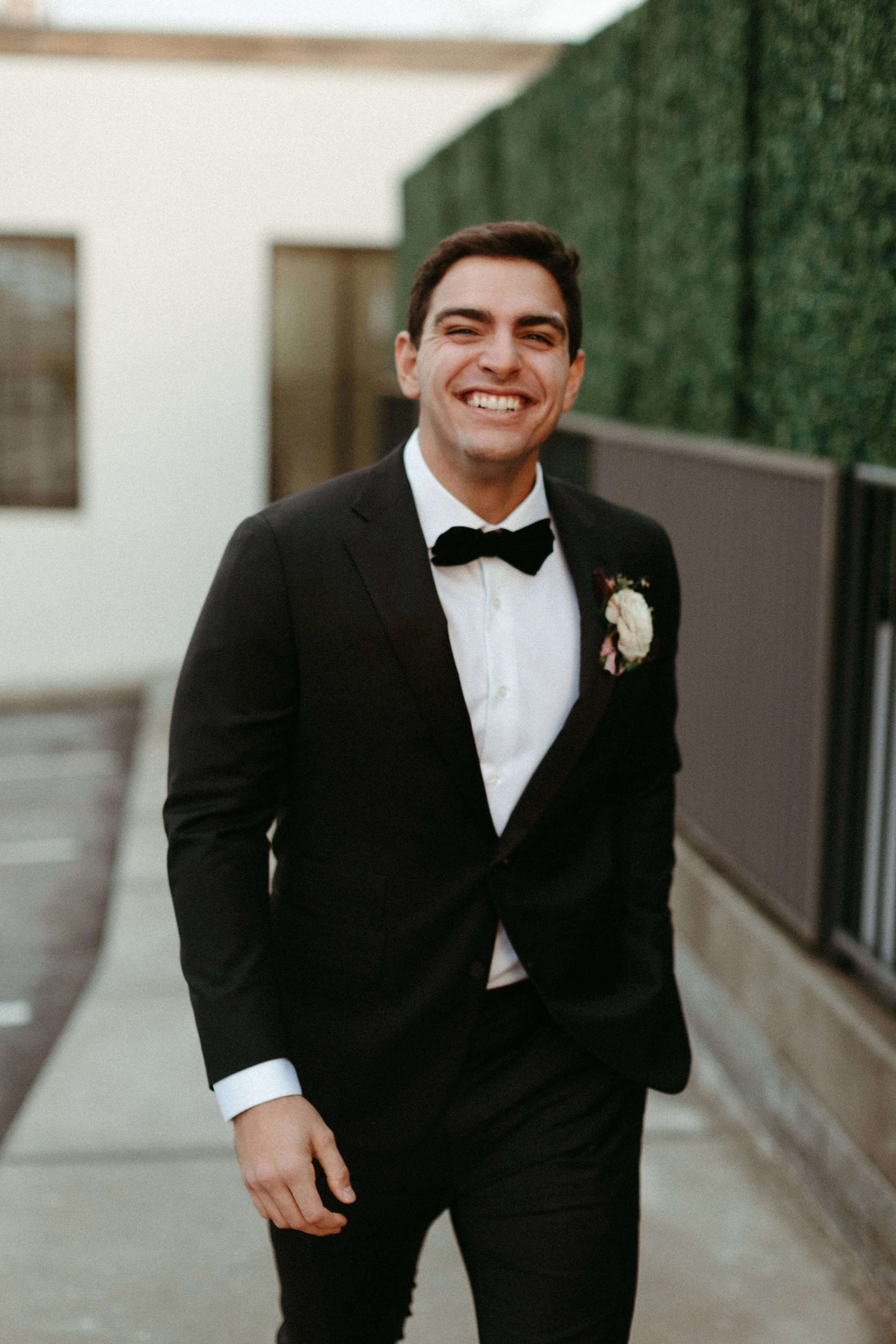 Boutonnieres of lush ranunculus and greenery decorate this 1920s inspired wedding bridal party. Neutral hues with accents of sage green and burgundy. Designed by Rosemary and Finch in Nashville, TN.