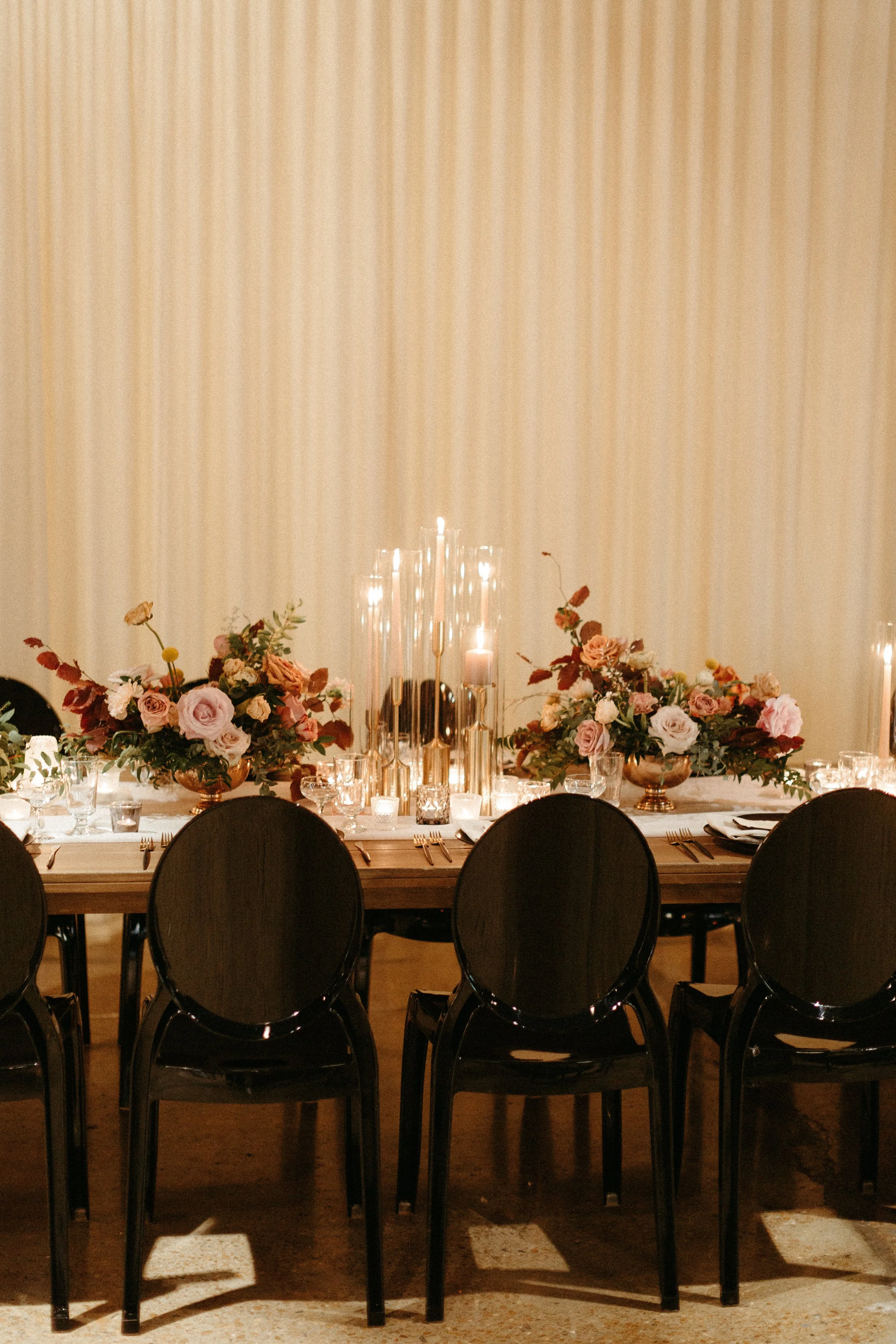 Gorgeous centerpieces bring warmth to this art deco 1920s inspired wedding with hues of terra cotta, dusty pink, mauve, and burgundy. Lush roses, ranunculus, and copper beech highlight the florals. Designed by Rosemary and Finch in Nashville, TN.