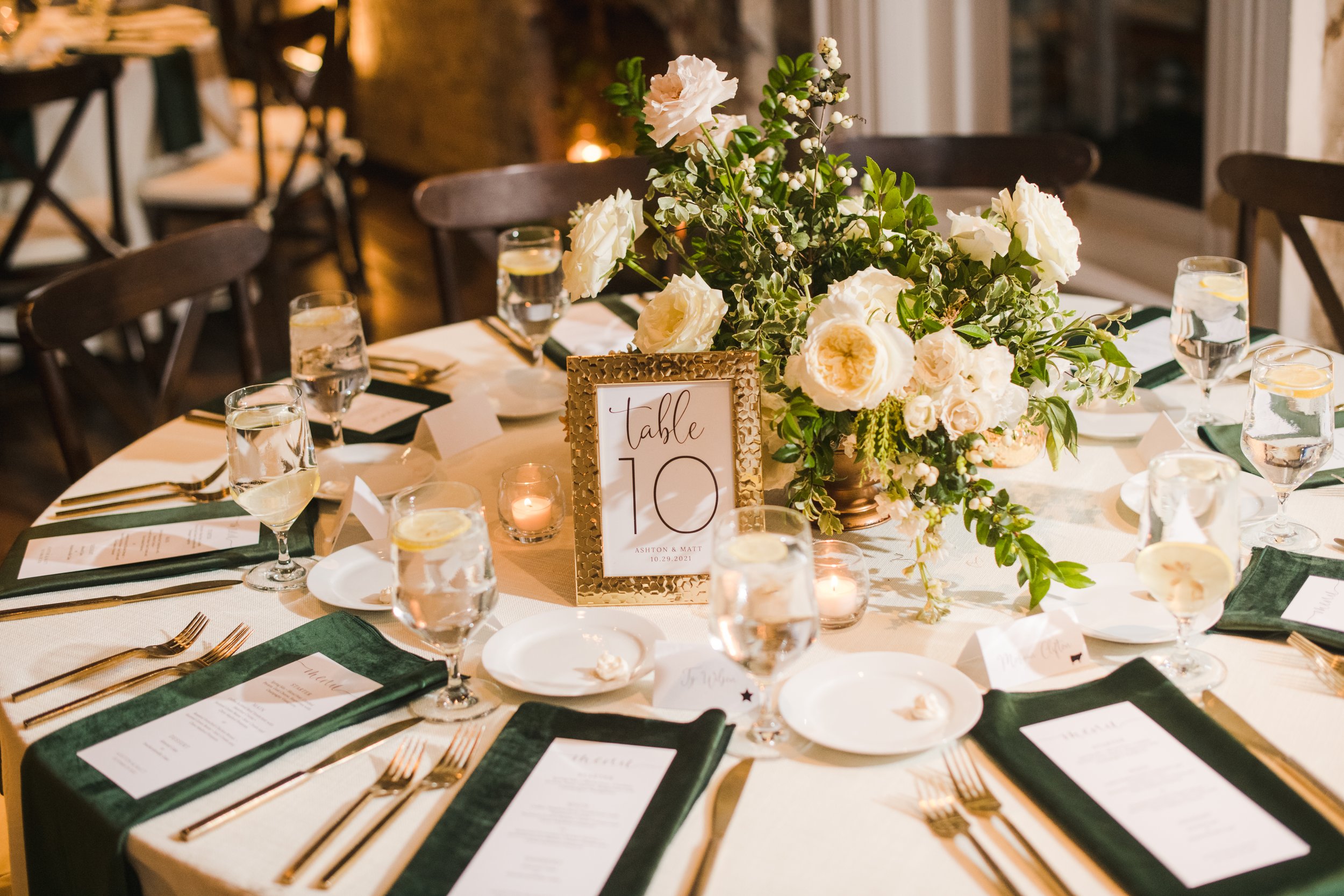 Low floral centerpieces for elegant winter wedding overflowing with white garden roses, dried hydrangeas, scabiosa, berries, lisianthus, ranunculus, and natural dark greenery. Designed by Rosemary and Finch in Nashville, TN.