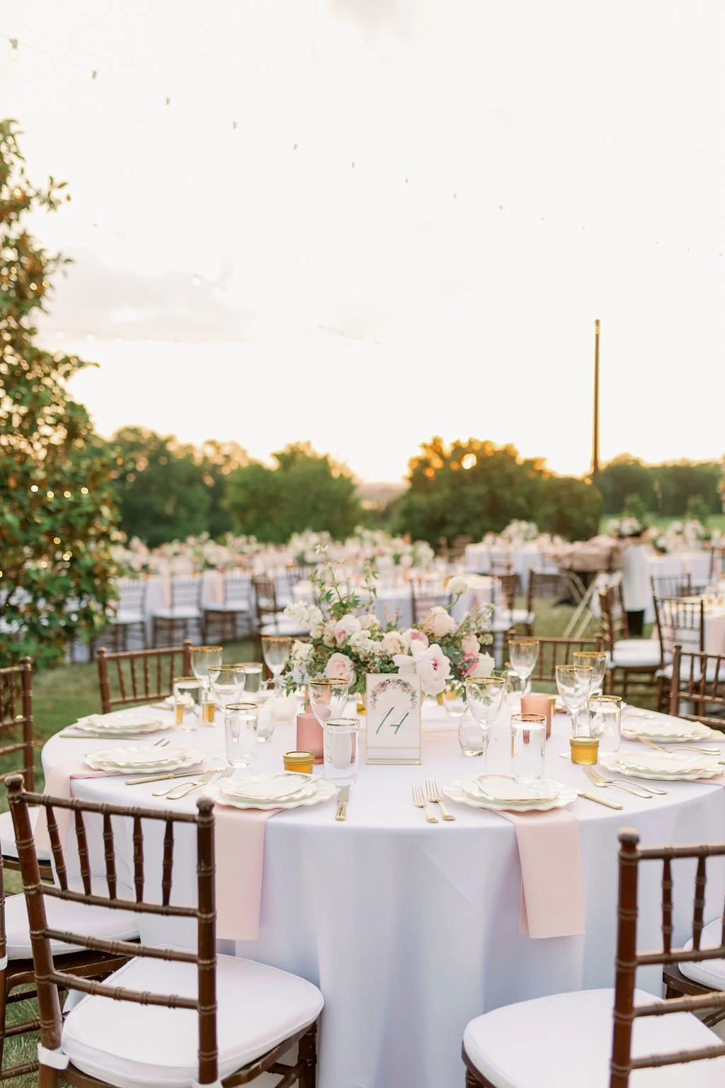 This garden-inspired reception features floral hues of blush, ivory, cream, pink, and hints of French blue along with centerpieces of pink roses, peonies, garden roses, blue delphinium, ranunculus, spirea and hydrangea. Designed by Rosemary & Finch i