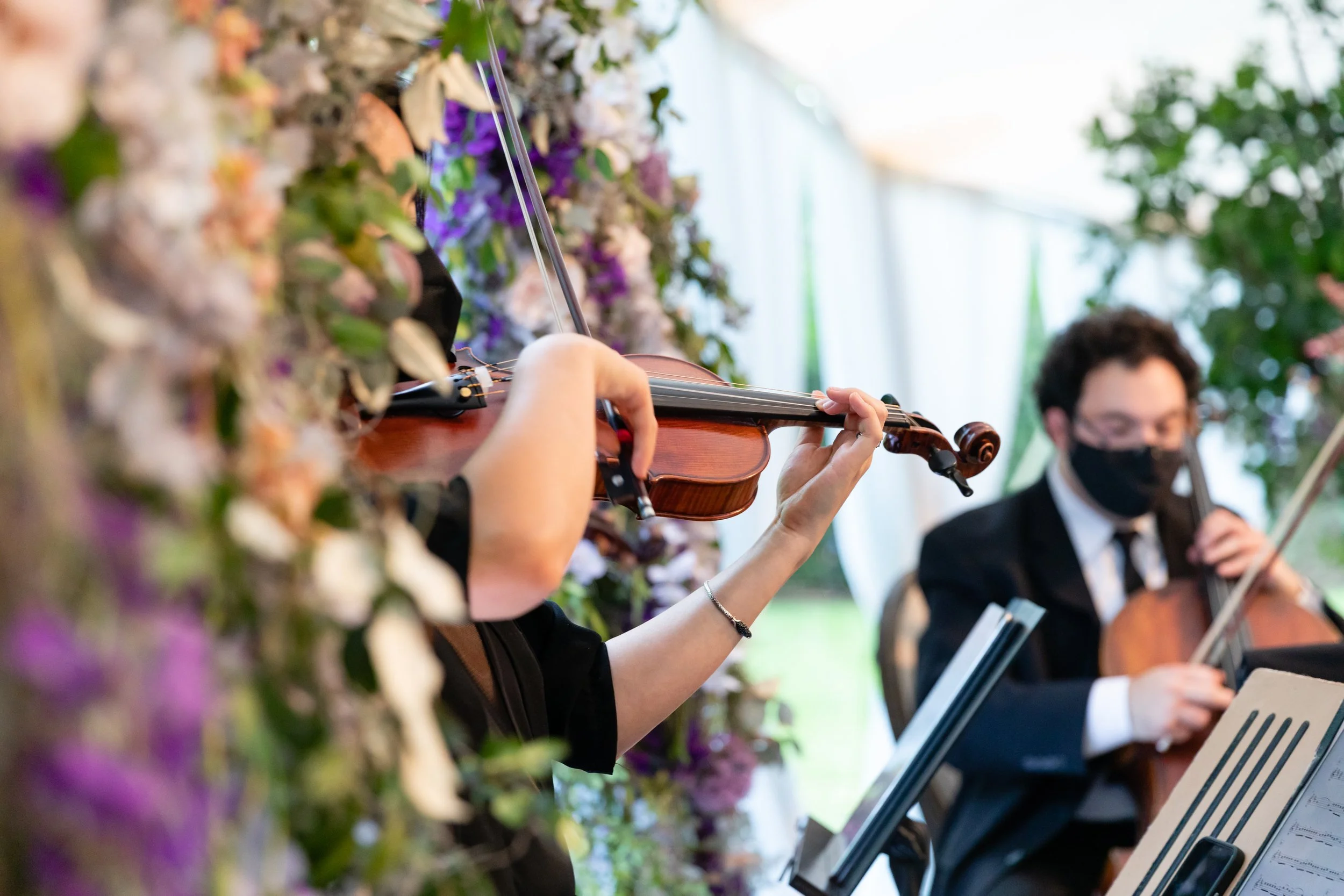 Growing, fresh floral installations with blush garden roses, lavender delphinium, wisteria, globe allium, and vines and greenery for a tented Bridgerton inspired engagement party at a private home in Nashville, TN. Flower by Tennessee based wedding f