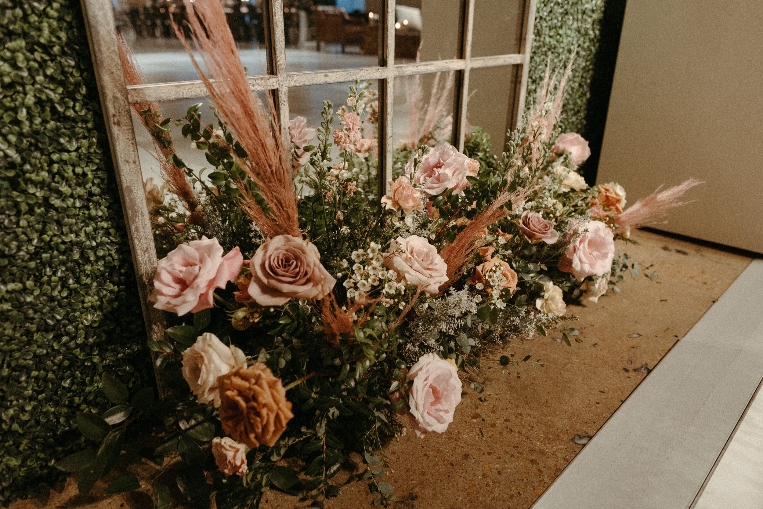 Stunning floral installations bring warmth to this Great Gatsby inspired wedding with florals of terra cotta, dusty pink, and burgundy hues. Petal heavy roses, wisteria, copper beech, and pink pampas grass accents. Designed by Rosemary and Finch in N