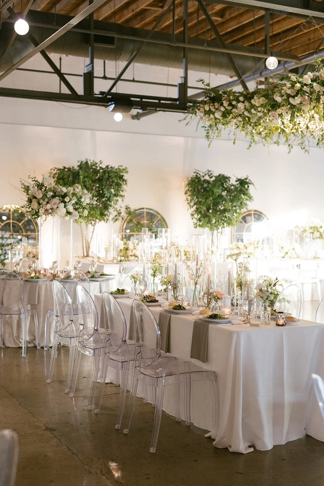 Elegant bud vases with florals of roses, ranunculus, sweet peas, Queen Anne’s lace, butterfly ranunculus in hues of white, cream and blush. Accented with dusty blue tapers and clear glass votives. Designed by Rosemary and Finch in Nashville, TN.