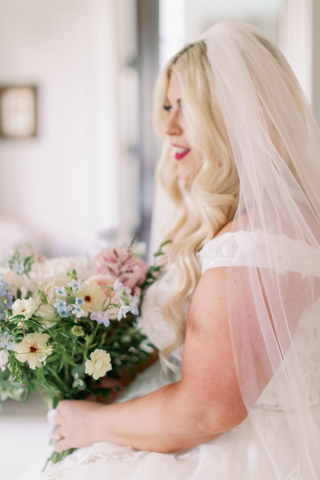A lush bridal bouquet filled with hues of blush, pink, ivory, and hints of French blue. Garden roses, majolica spray roses, champagne roses, peonies, ranunculus, delphinium, and spirea make up this fairytale bouquet. Designed by Rosemary & Finch in N