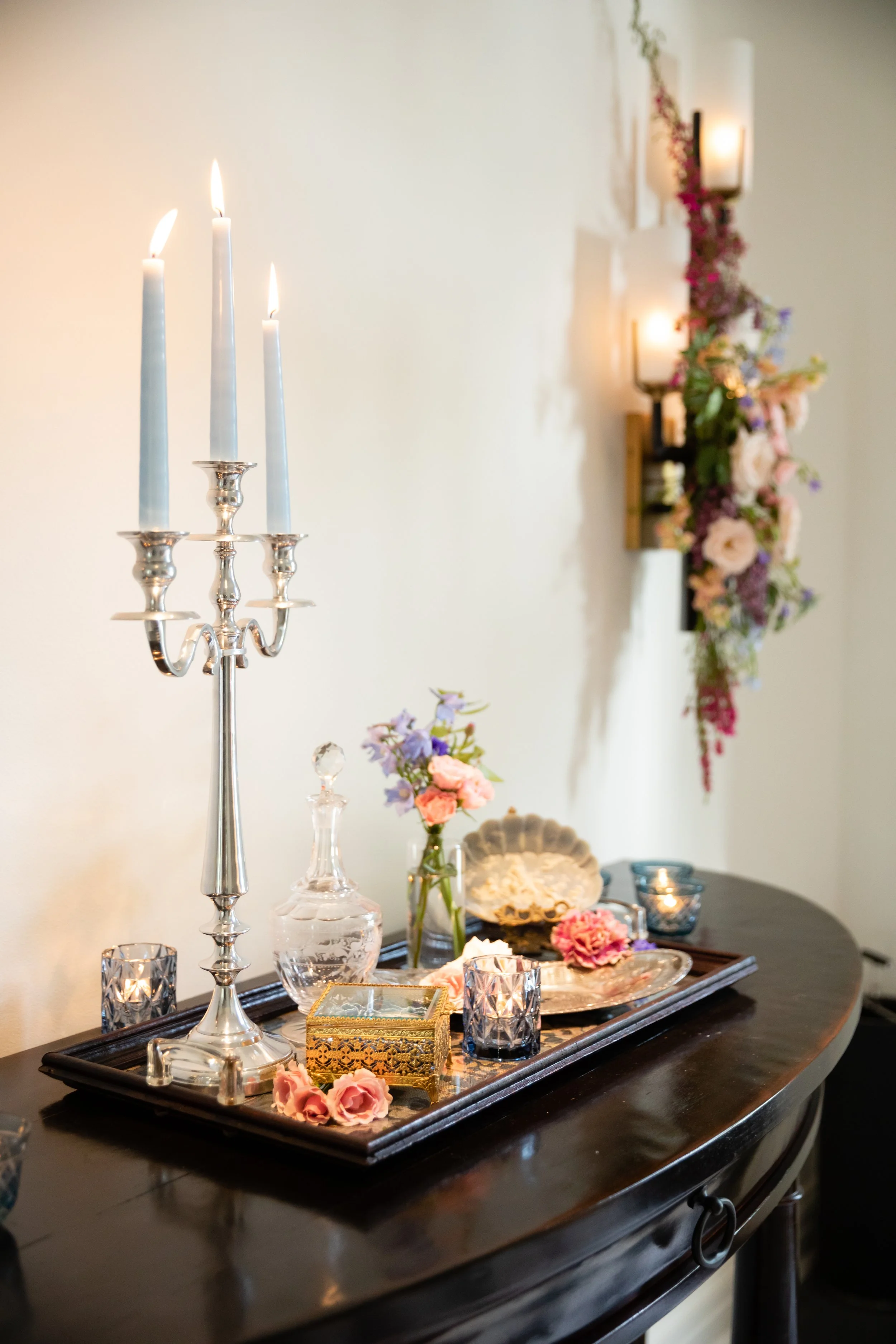 Bridgerton inspired engagement party at a private home in Nashville, TN with lush, organic florals of wisteria, spanish moss, and pastel blooms. Silver candelabra with light blue tapers and styled flowers.