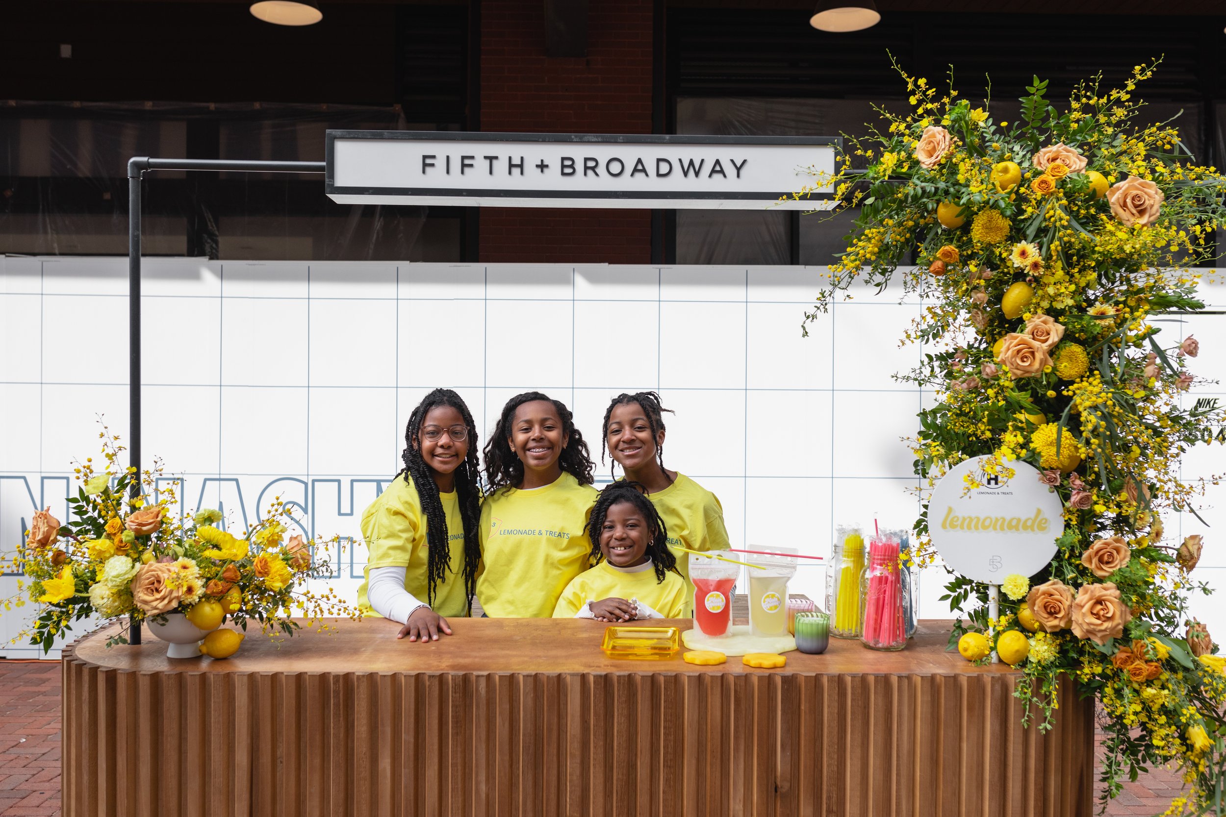 Bold spring floral installation of yellow and green hues comprised of roses, mums, orchids, tulips, carnations, mixed greenery, and lemons! Designed by Rosemary and Finch for Fifth + Broadway event in Downtown Nashville, TN.