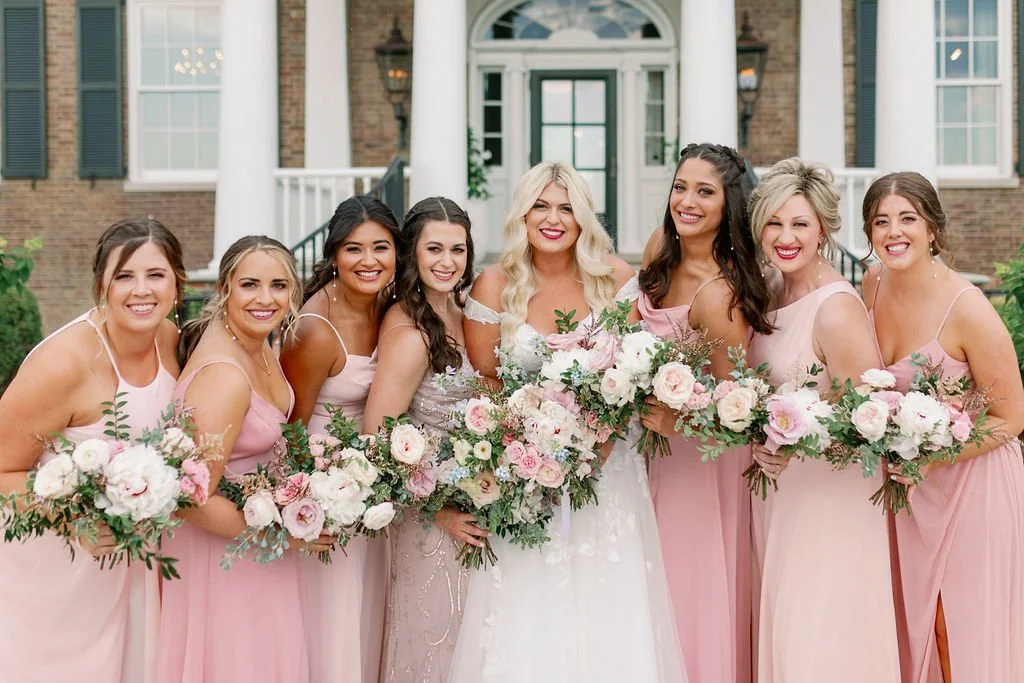 A lush bridal bouquet filled with hues of blush, pink, ivory, and hints of French blue. Garden roses, majolica spray roses, champagne roses, peonies, ranunculus, delphinium, and spirea make up this fairytale bouquet. Designed by Rosemary & Finch in N