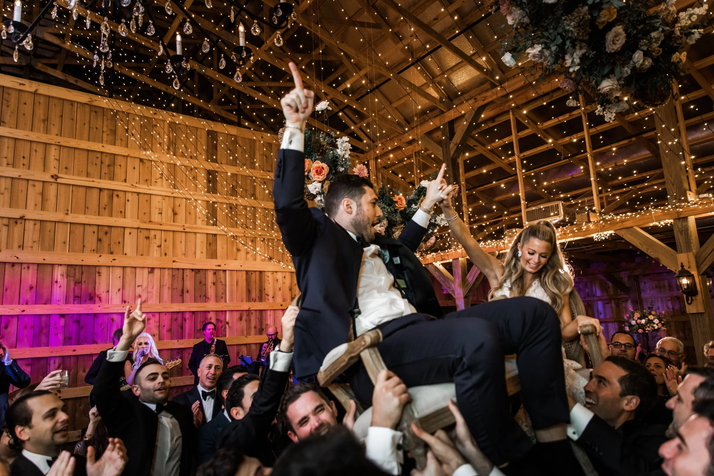 Gorgeous autumnal floral clouds hang over the dance floor, including terra cotta, rose gold, toffee, blush, and neutral florals. These clouds feature lush garden roses, ranunculus, lisianthus, and privet berries. Designed by Rosemary and Finch in Nas