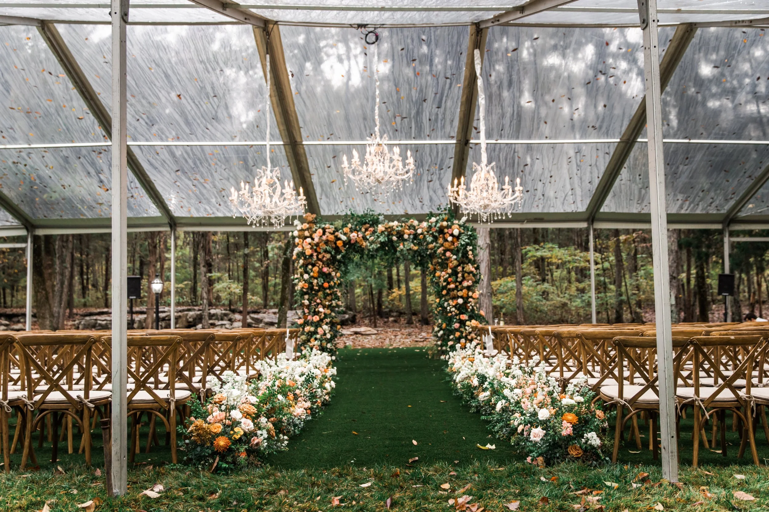 Lush floral hedges create aisle meadows for this fall wedding. Florals feature hues of terra cotta, blush, yellow, copper, and neutrals. Beautiful garden roses, dahlias, and fall florals highlight these arrangements. Design by Rosemary and Finch in N