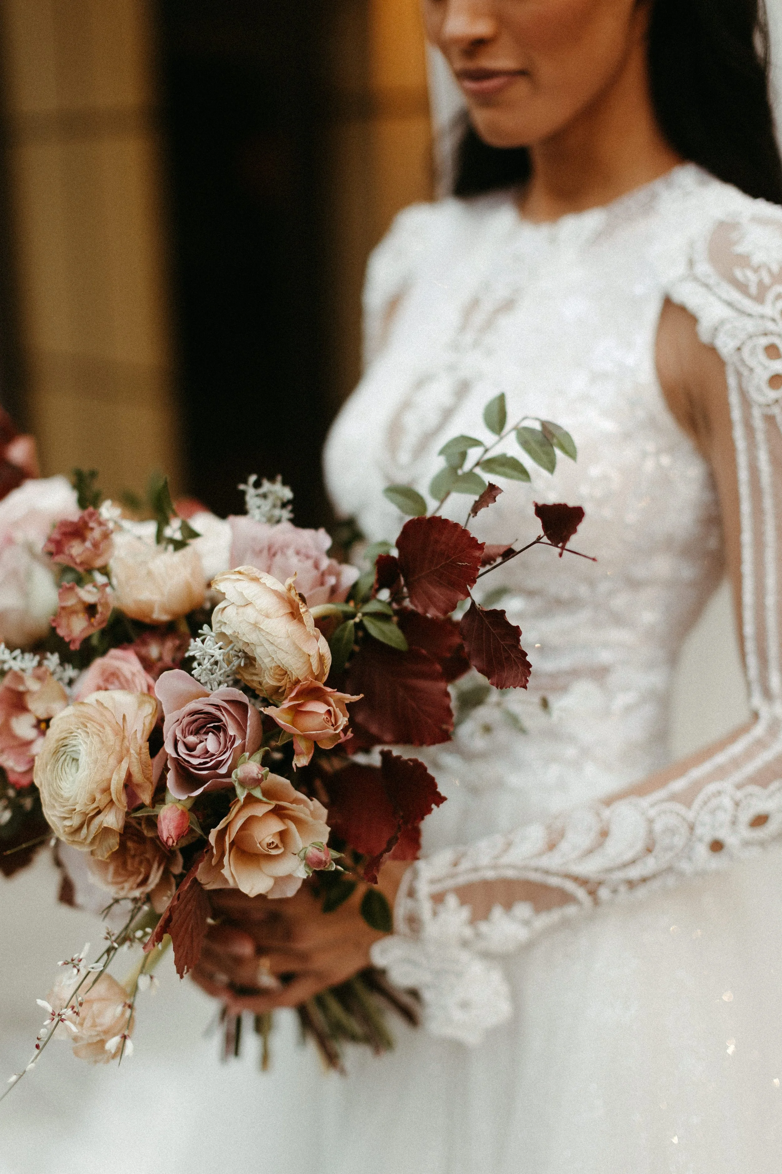 This elegant bridal bouquet brought hues of mauve, dusty pink, cream, burgundy, and terra cotta to this winter wedding. Lush with petal heavy roses, ranunculus, spray roses, copper beech, and greenery. Designed by Rosemary and Finch in Nashville, TN.
