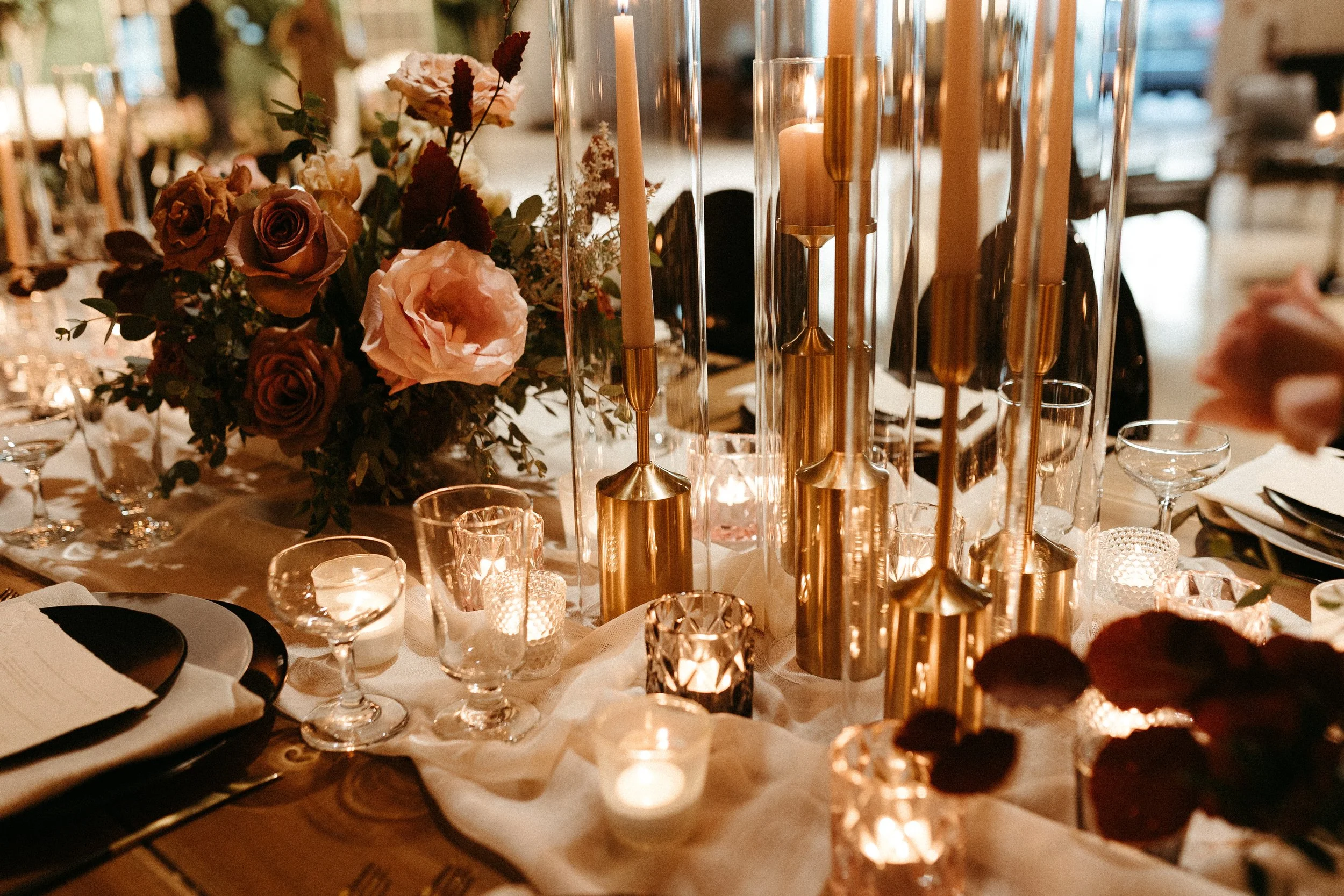 Gorgeous centerpieces bring warmth to this art deco 1920s inspired wedding with hues of terra cotta, dusty pink, mauve, and burgundy. Lush roses, ranunculus, and copper beech highlight the florals. Designed by Rosemary and Finch in Nashville, TN.