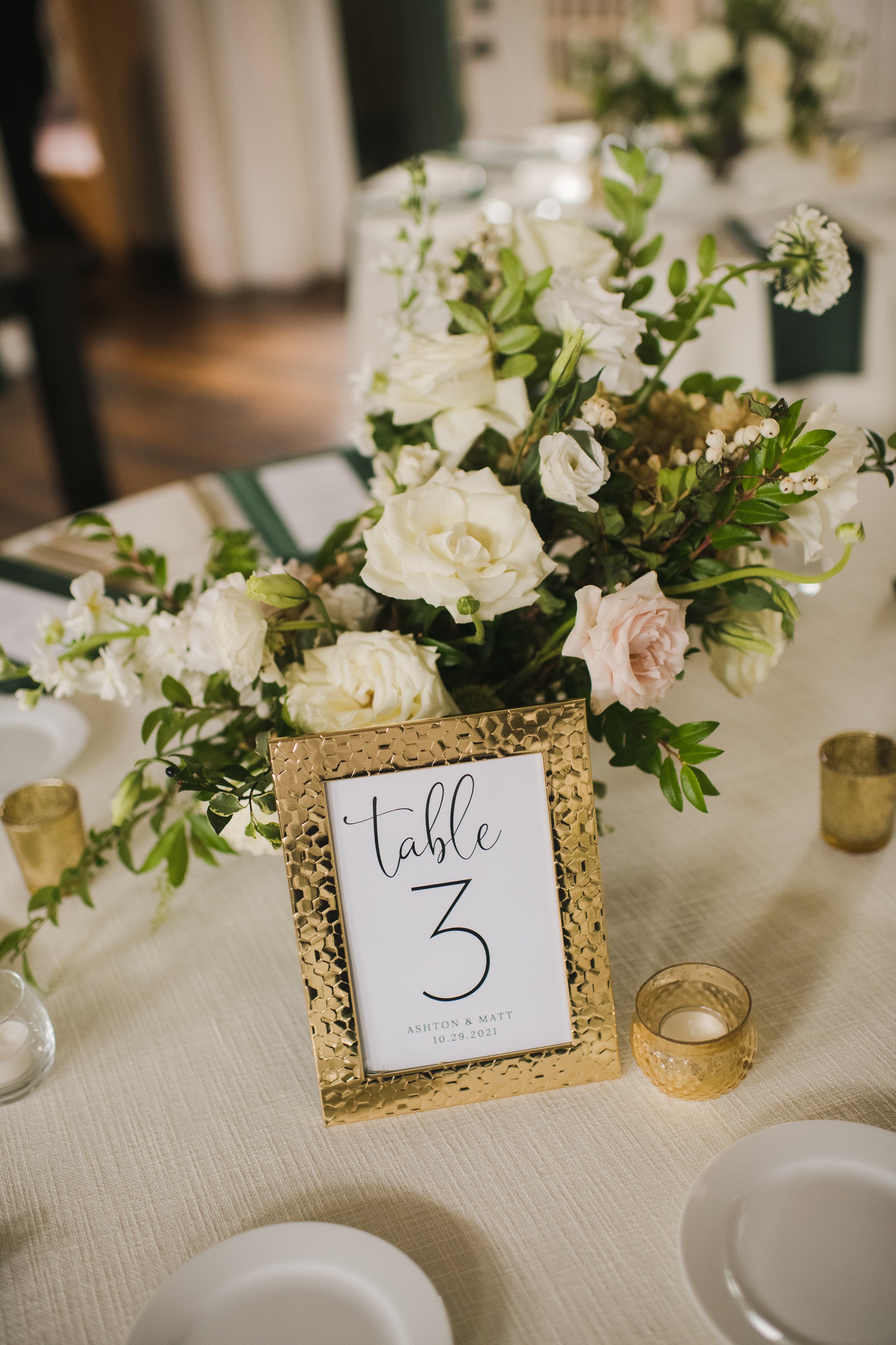 Low floral centerpieces for elegant winter wedding overflowing with white garden roses, dried hydrangeas, scabiosa, berries, lisianthus, ranunculus, and natural dark greenery. Designed by Rosemary and Finch in Nashville, TN.