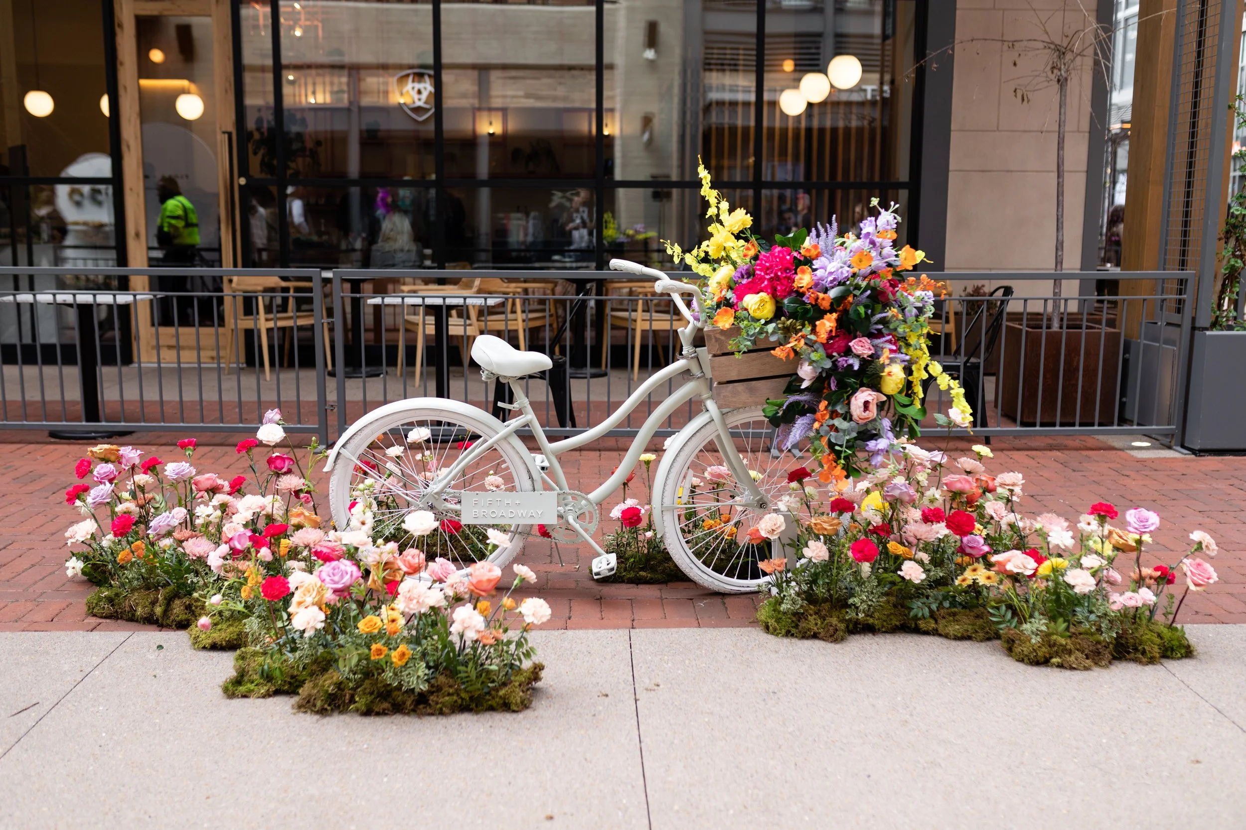 Vibrant floral installations composed of silk floral hues in pink, magenta, lavender, coral, orange, yellow, and mixed greens bring to life this spring Fifth + Broadway event in Nashville, TN. Design by Rosemary and Finch.