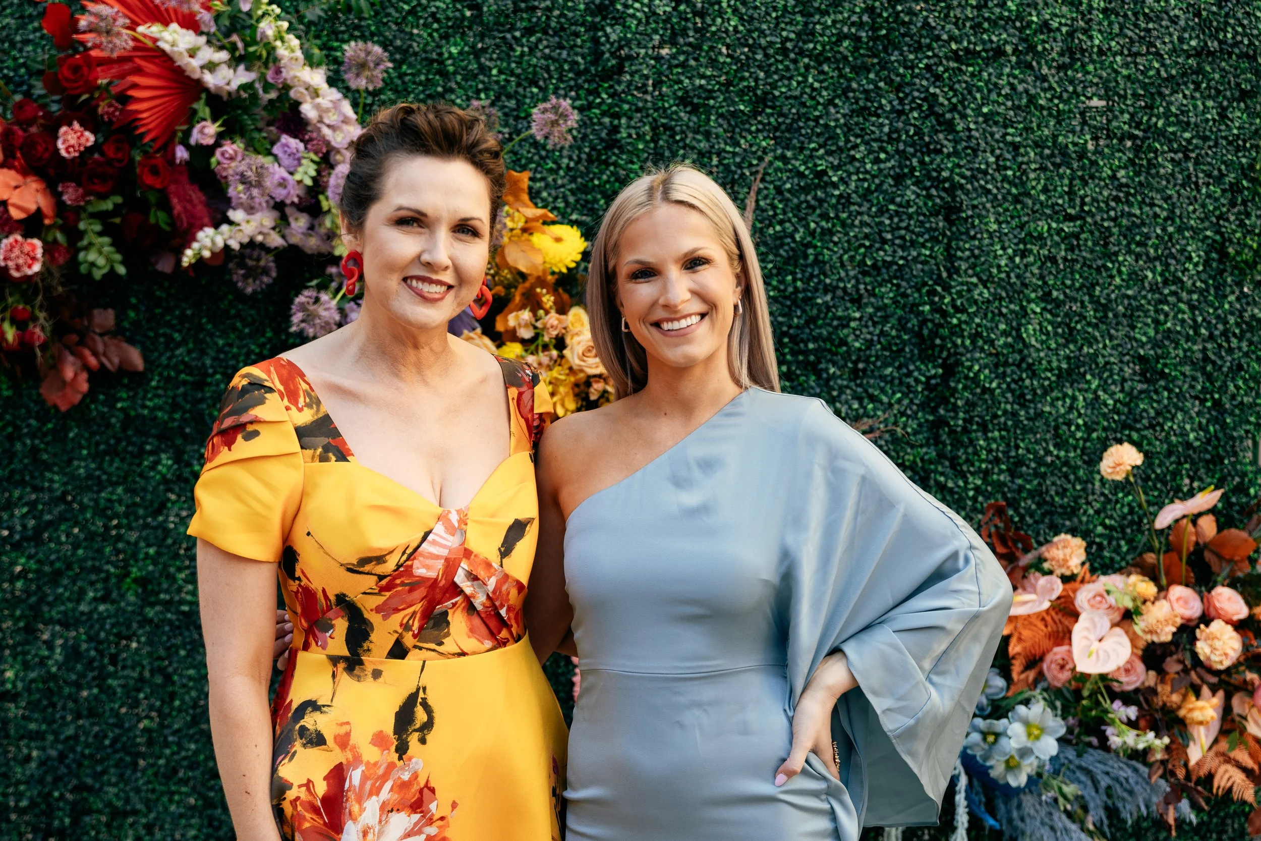 Modern colorful photo wall with rainbow hues of red, purple, yellow, blue, and orange. Comprised of roses, hydrangeas, tulips, snapdragons, dried palms, and anthurium. Designed by Rosemary and Finch in Nashville, TN.