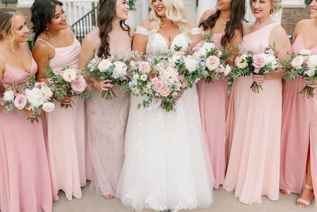 A lush bridal bouquet filled with hues of blush, pink, ivory, and hints of French blue. Garden roses, majolica spray roses, champagne roses, peonies, ranunculus, delphinium, and spirea make up this fairytale bouquet. Designed by Rosemary & Finch in N