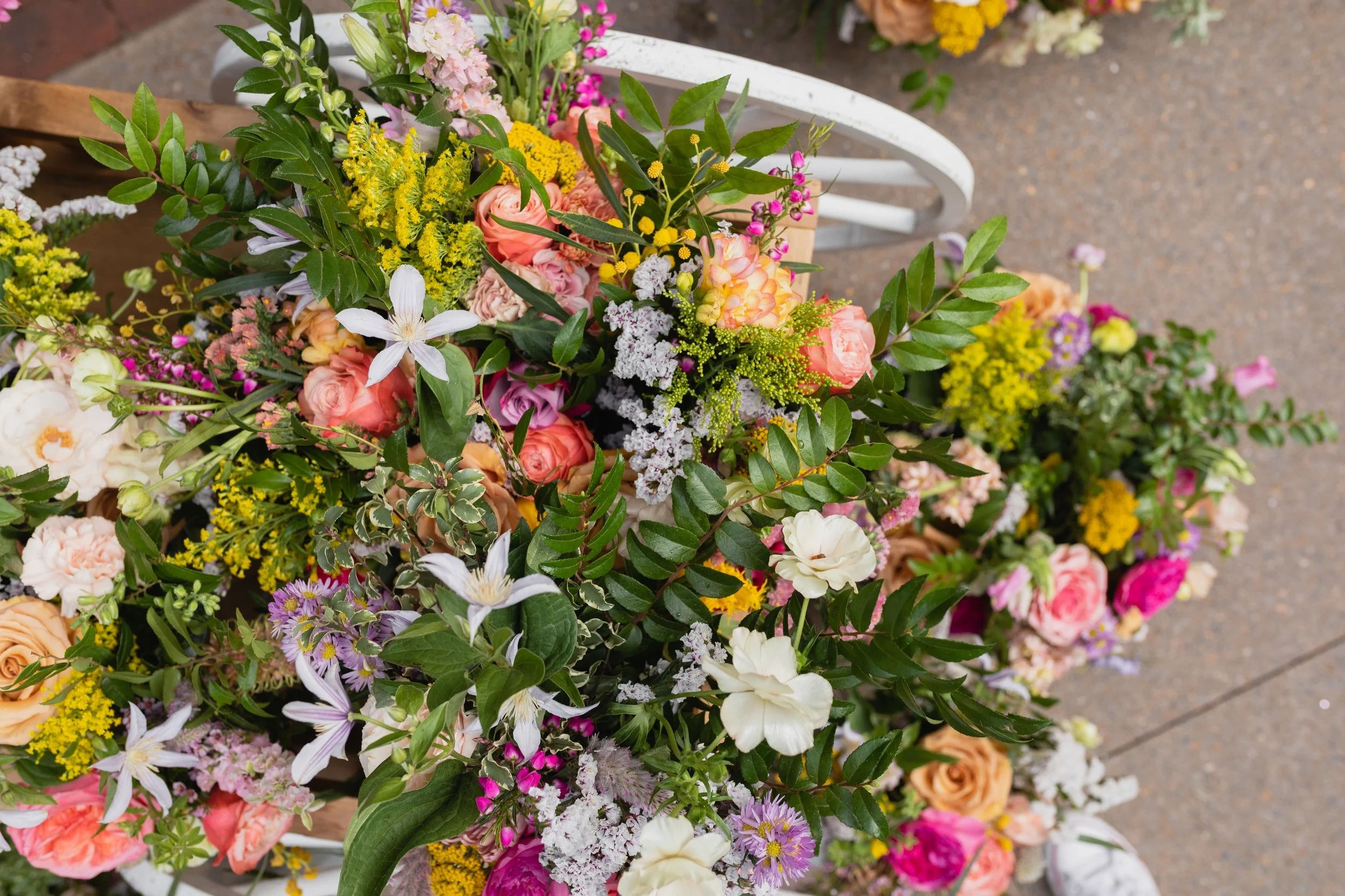 Bright spring floral hues of pink, lavender, coral, magenta, and yellow inspire the event space of Fifth + Broadway in Nashville, TN. Florals composed of roses, ranunculus, sweet peas, butterfly ranunculus, mixed greenery. Design by Rosemary and Finc