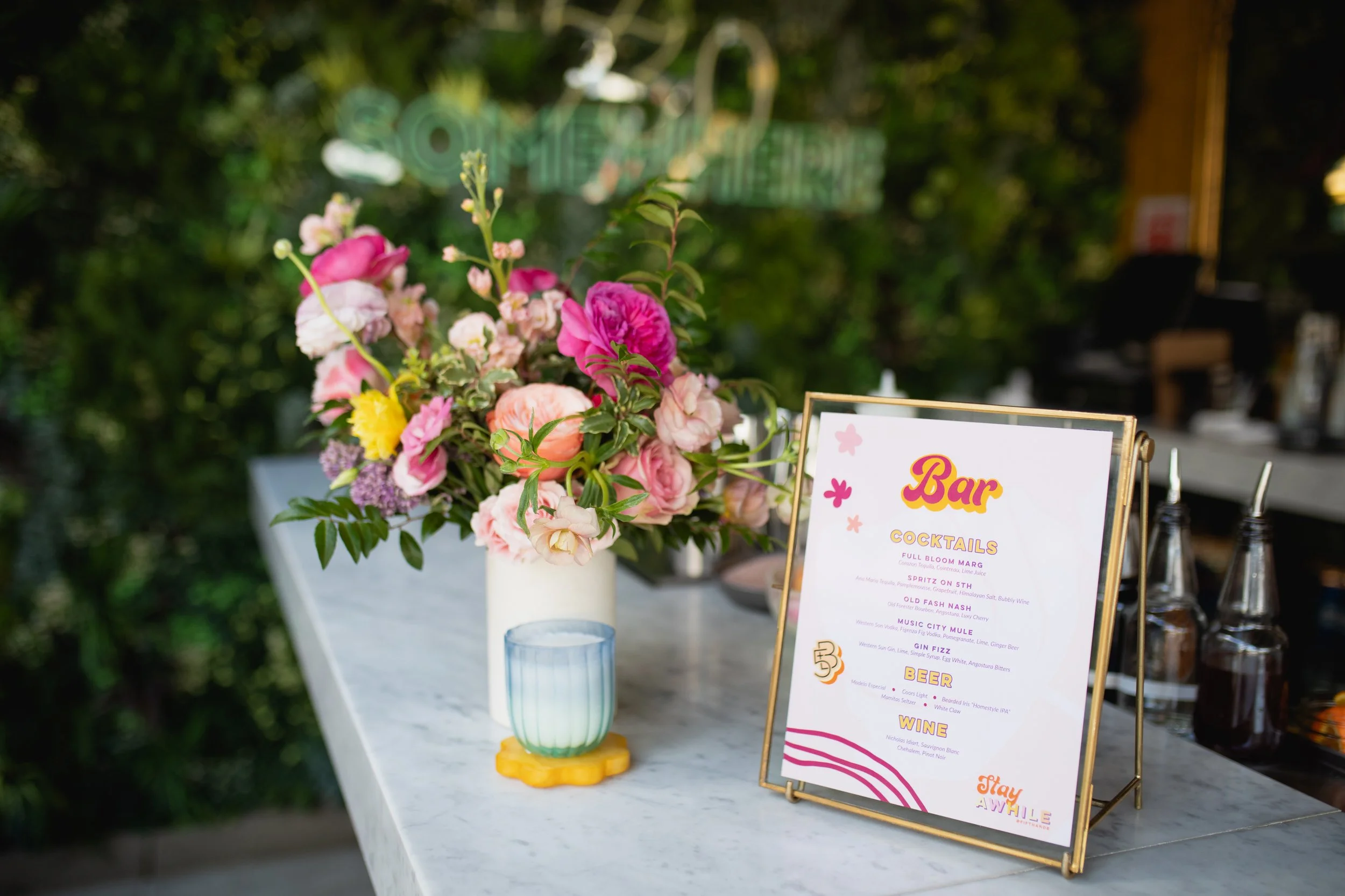 Bright spring floral hues of pink, lavender, coral, magenta, and yellow inspire the event space of Fifth + Broadway in Nashville, TN. Florals composed of roses, ranunculus, sweet peas, butterfly ranunculus, mixed greenery. Design by Rosemary and Finc