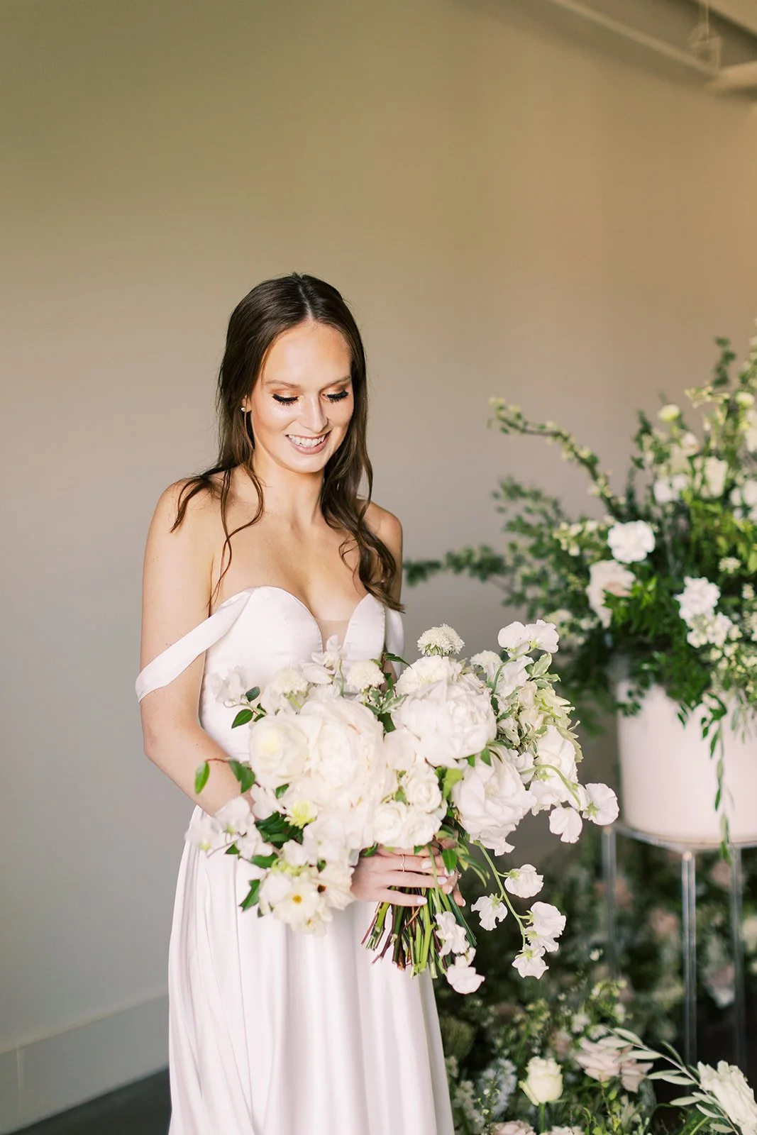Bridal bouquet of white garden roses, peonies, ranunculus, sweet peas, scabiosa, butterfly ranunculus and dark greenery in floral hues of white, cream, and blush. Designed by Rosemary and Finch in Nashville, TN.