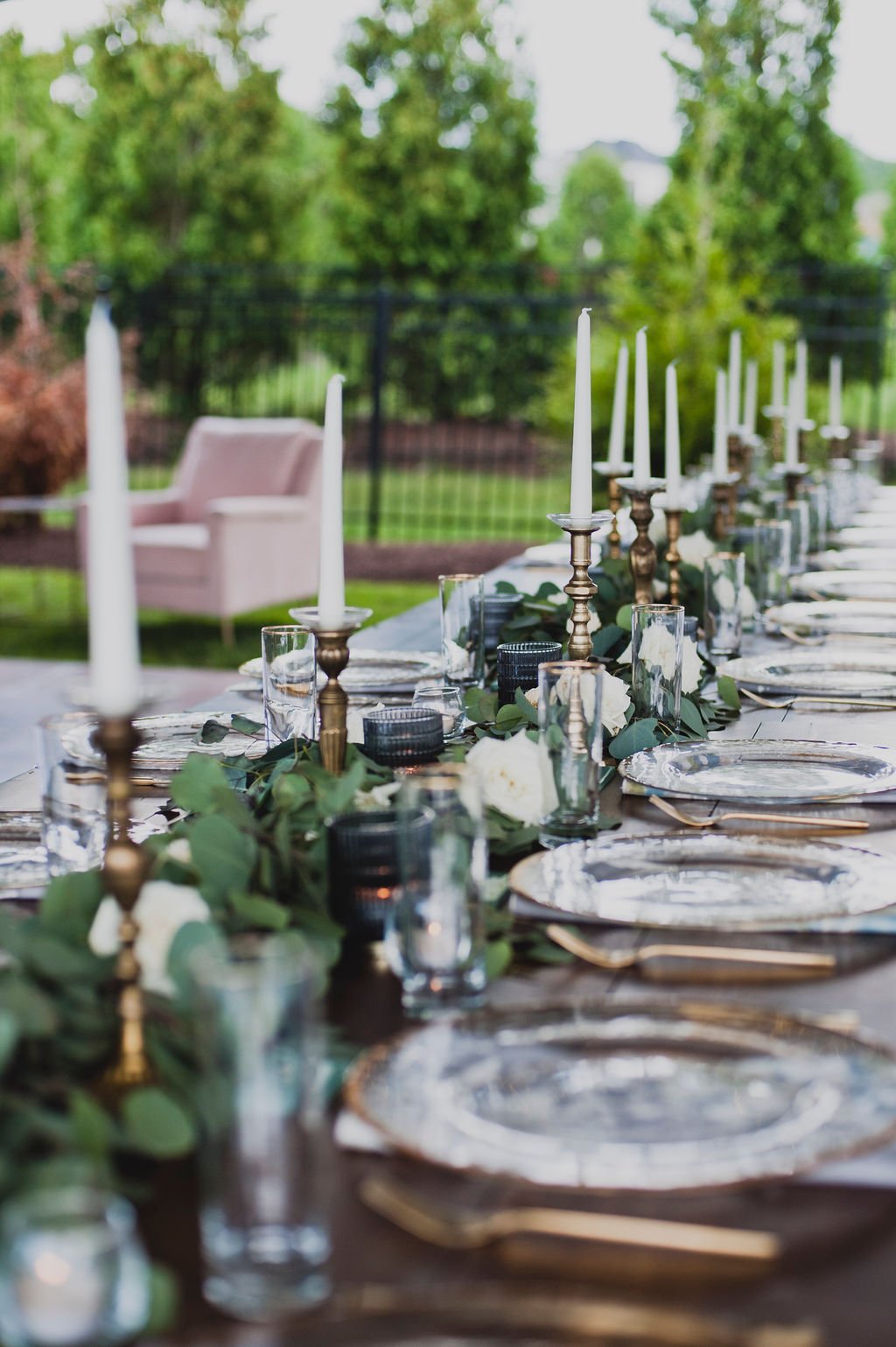 This backyard reception had a lush head table filled with garlands of eucalyptus, garden roses, ruscus, and spray roses. Designed by Rosemary and Finch in Nashville, TN.