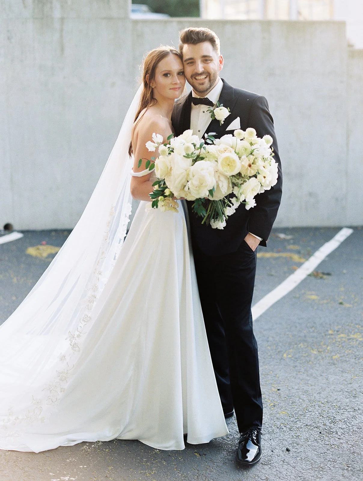 Bridal bouquet of white garden roses, peonies, ranunculus, sweet peas, scabiosa, butterfly ranunculus and dark greenery in floral hues of white, cream, and blush. Designed by Rosemary and Finch in Nashville, TN.