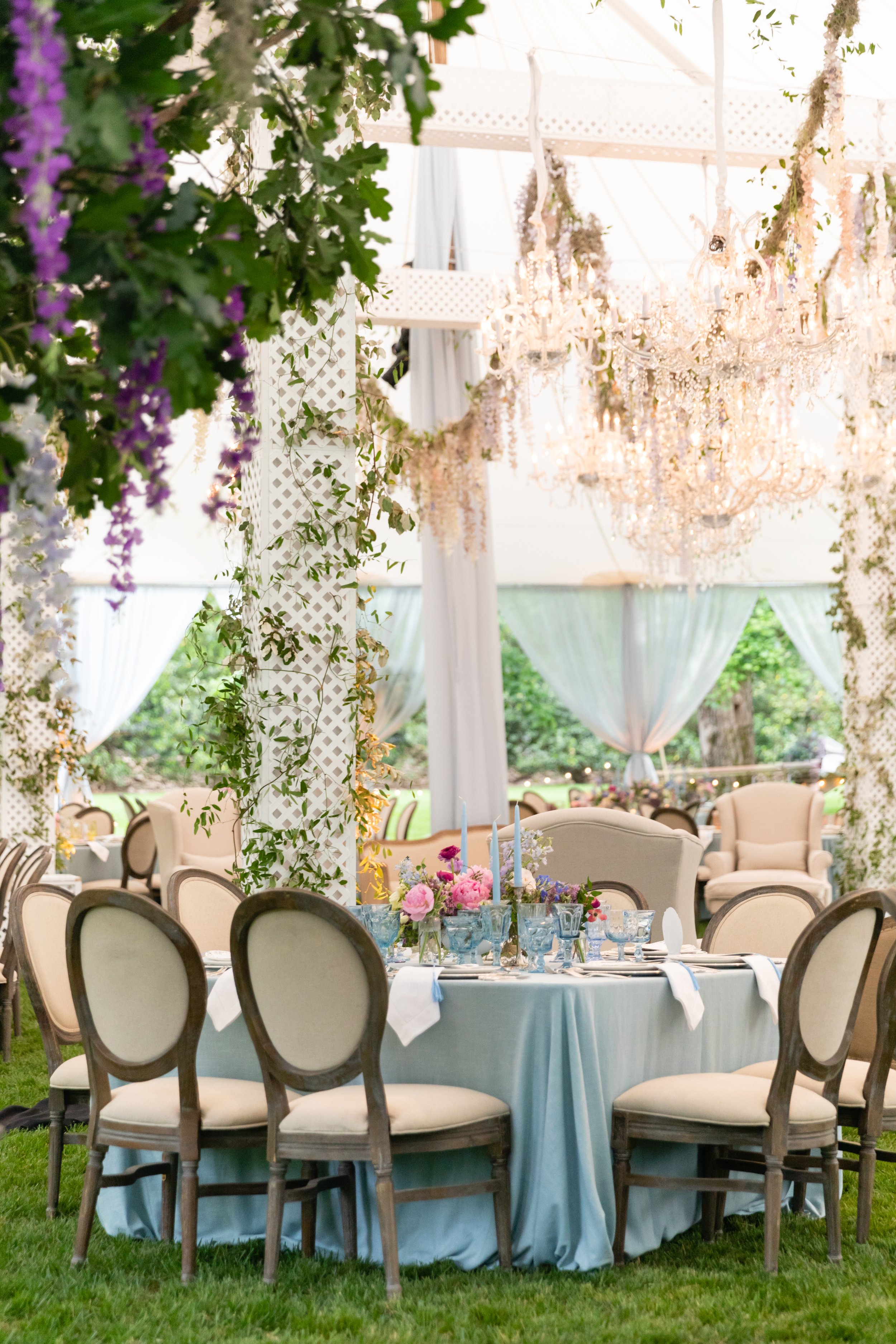 Growing, fresh floral installations with blush garden roses, lavender delphinium, globe allium, and vines and greenery for a tented Bridgerton inspired engagement party at a private home in Nashville, TN. Flower by Tennessee based wedding floral desi