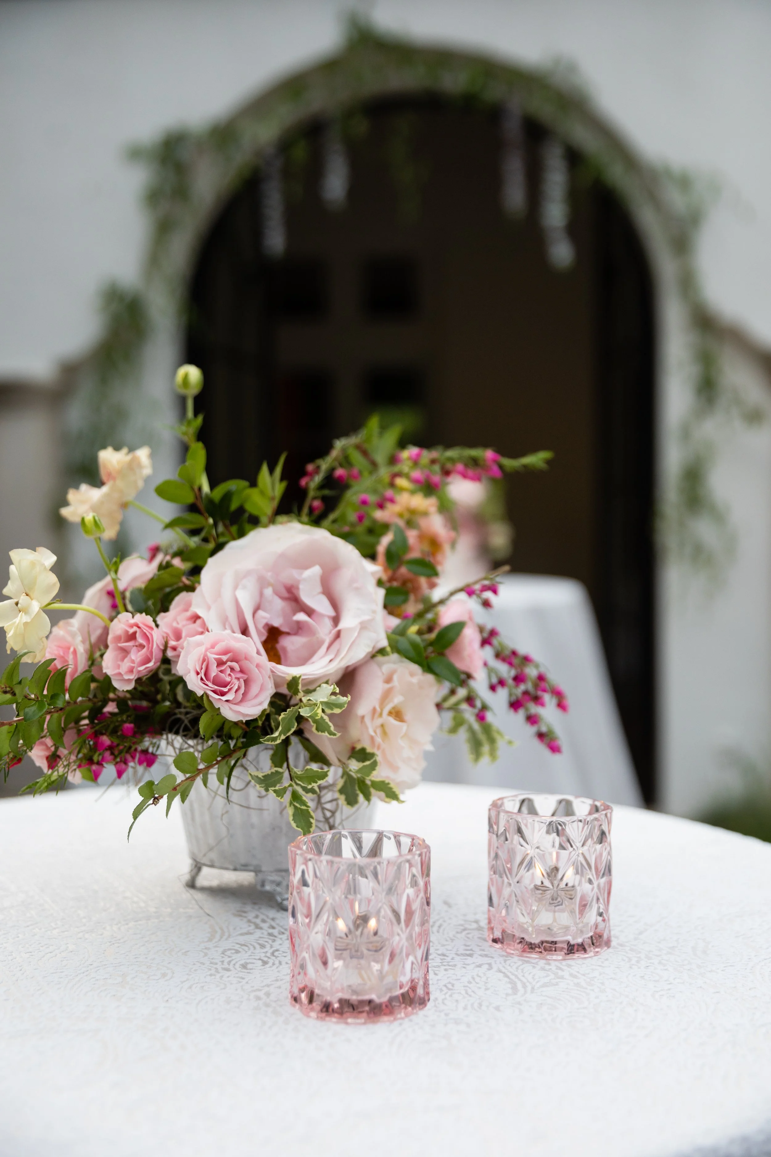 Bridgerton inspired engagement party at a private home in Nashville, TN with color blocked flower arrangements in shades of pink, blue, and lavender with matching votives candles. Natural greenery, garden roses, ranunculus, and wildflowers.