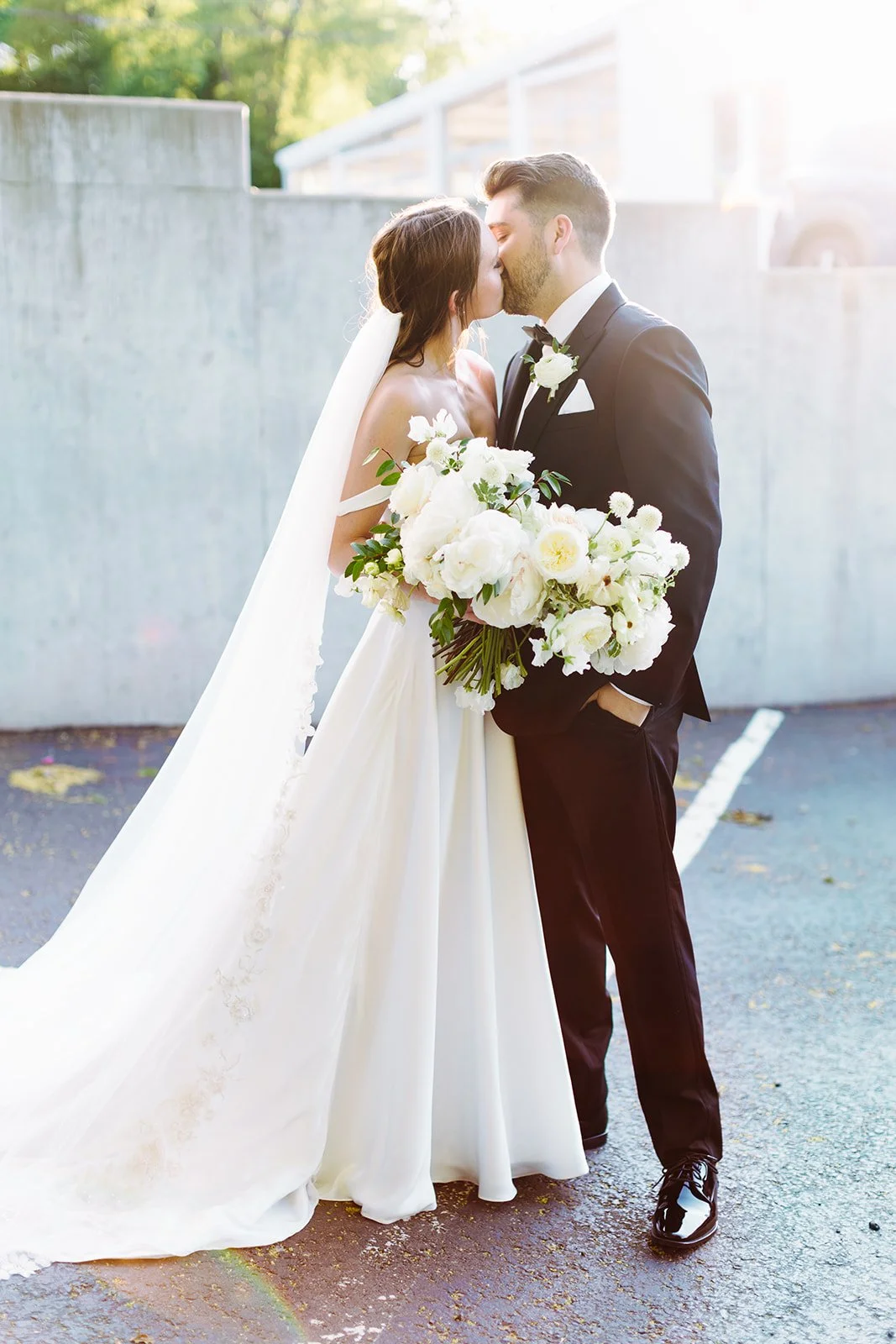 Bridal bouquet of white garden roses, peonies, ranunculus, sweet peas, scabiosa, butterfly ranunculus and dark greenery in floral hues of white, cream, and blush. Designed by Rosemary and Finch in Nashville, TN.