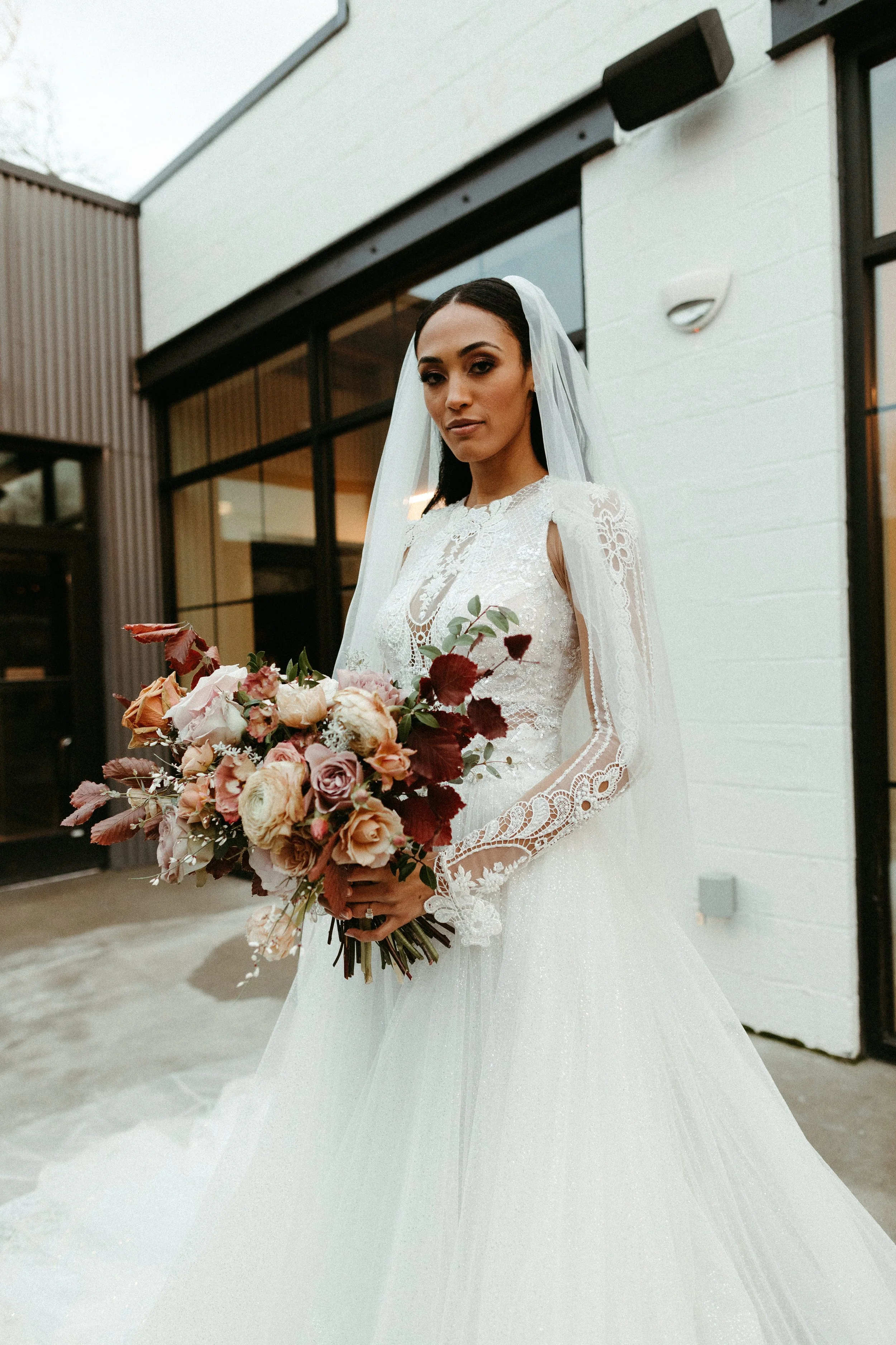 This elegant bridal bouquet brought hues of mauve, dusty pink, cream, burgundy, and terra cotta to this winter wedding. Lush with petal heavy roses, ranunculus, spray roses, copper beech, and greenery. Designed by Rosemary and Finch in Nashville, TN.