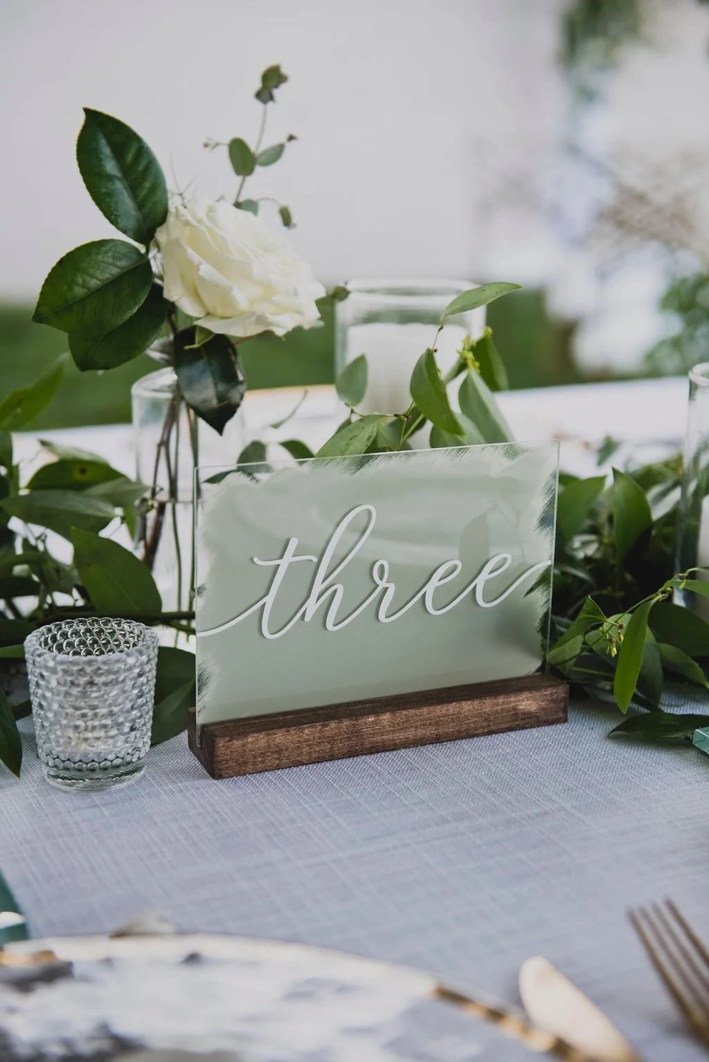 This backyard reception had a lush head table filled with garlands of eucalyptus, garden roses, ruscus, and spray roses. Designed by Rosemary and Finch in Nashville, TN.