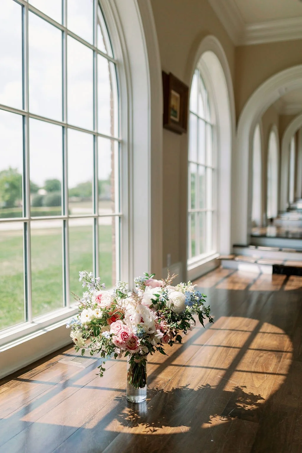 A lush bridal bouquet filled with hues of blush, pink, ivory, and hints of French blue. Garden roses, majolica spray roses, champagne roses, peonies, ranunculus, delphinium, and spirea make up this fairytale bouquet. Designed by Rosemary & Finch in N