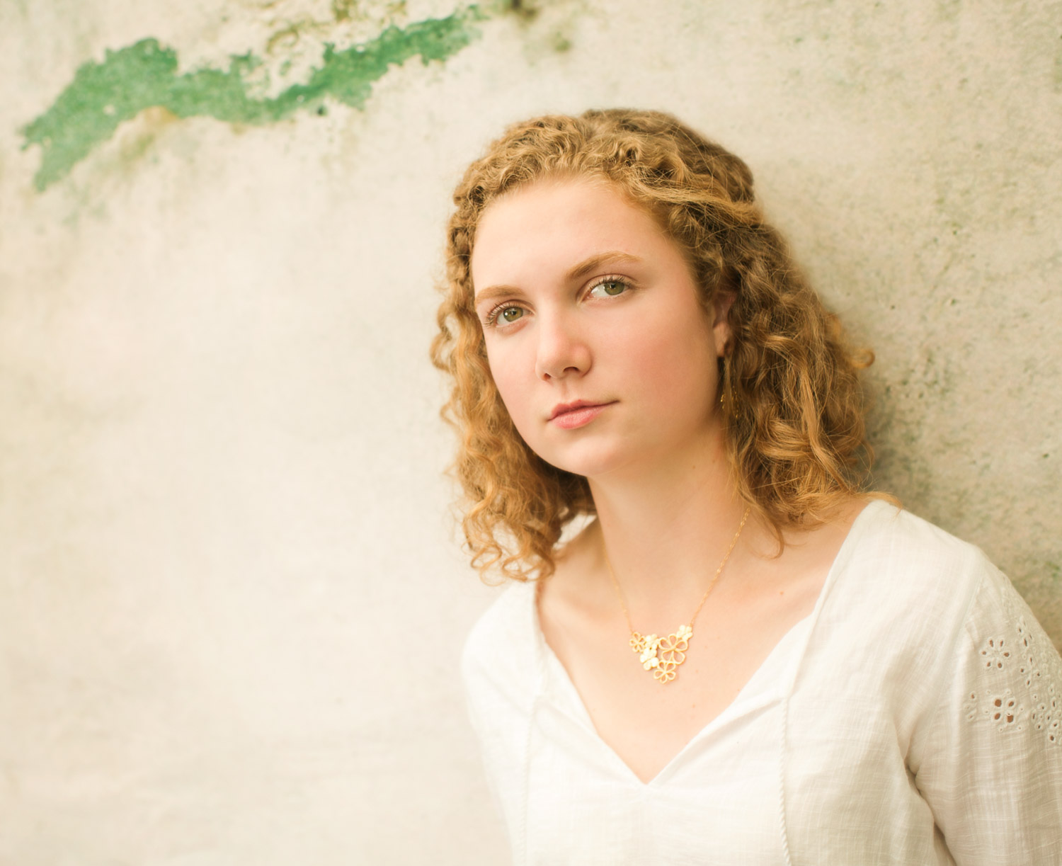  High school senior portrait of a young woman standing in front of a gray background, photographed by the Portland high school senior photographers at Campbell Salgado Studio in Portland, Oregon 