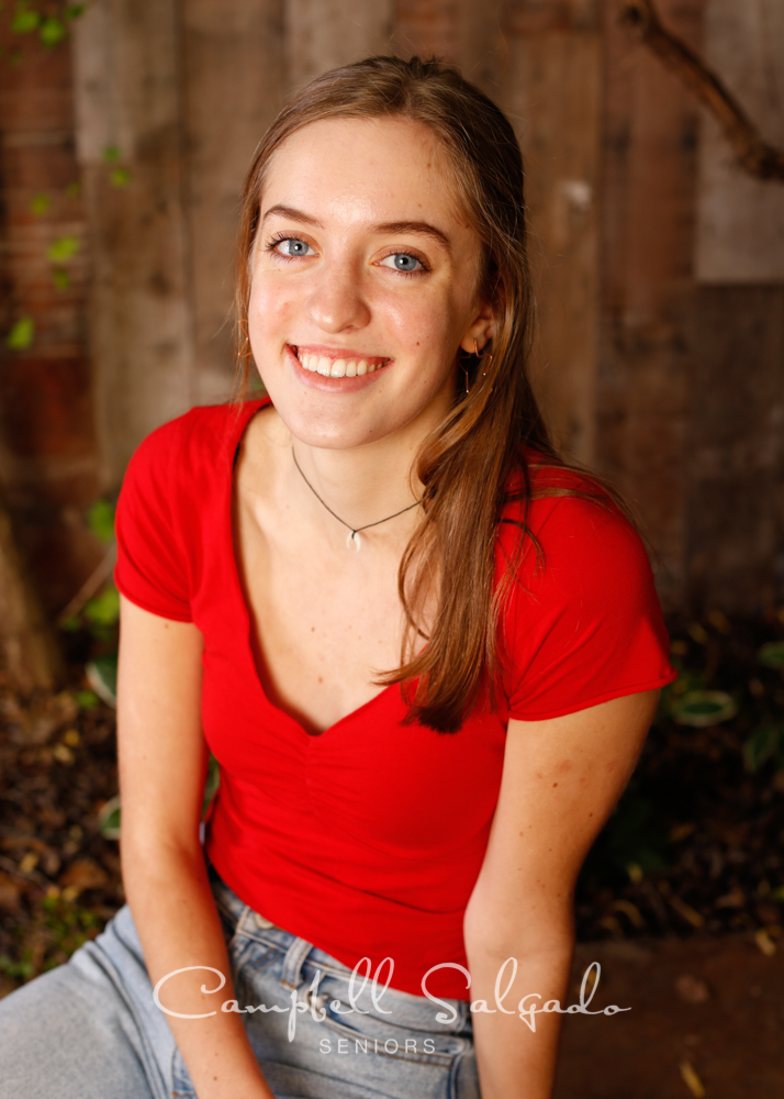  Professional senior portraits of young woman in front of a wooden wall background by Portland, Oregon photographers at Campbell Salgado Studio. 