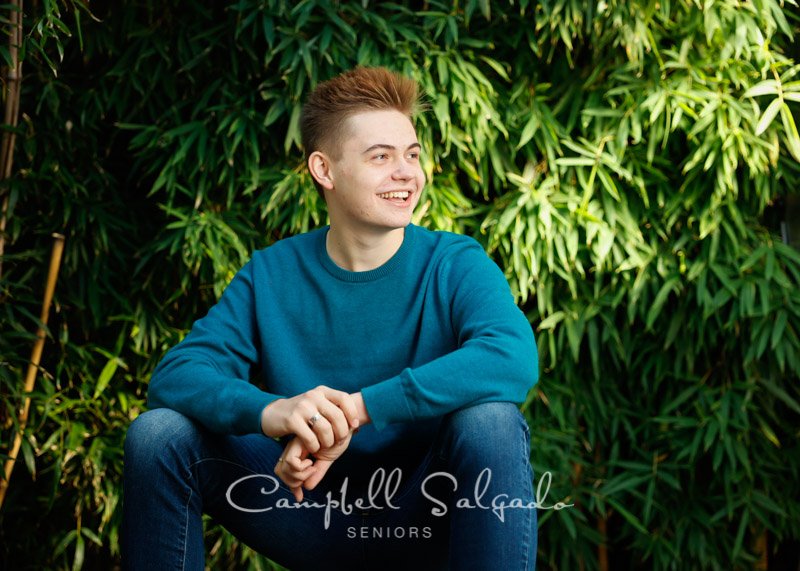  High school senior portrait photography of a young man in front of a bamboo background by senior photographers at Campbell Salgado Studio in Portland, Oregon. 